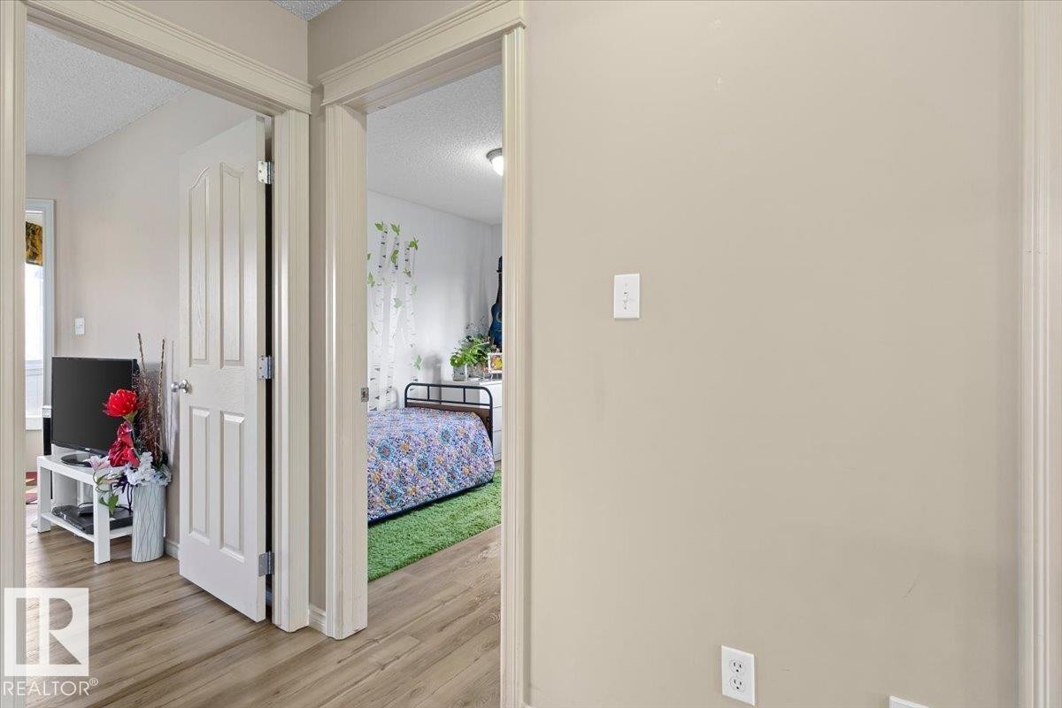 Hallway with light beige wall paint, white trim, and wood-finish flooring - 3356 25 Ave, Edmonton, AB - Indoor Photo Showing Other Room