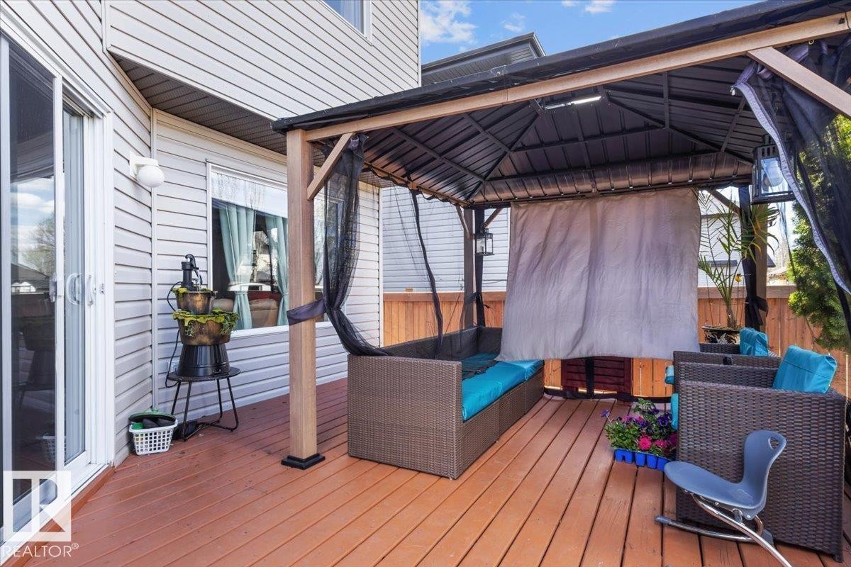 Spacious outdoor deck featuring wood-finish flooring and an attached gazebo with a metal frame - 3356 25 Ave, Edmonton, AB - Outdoor With Deck Patio Veranda With Exterior