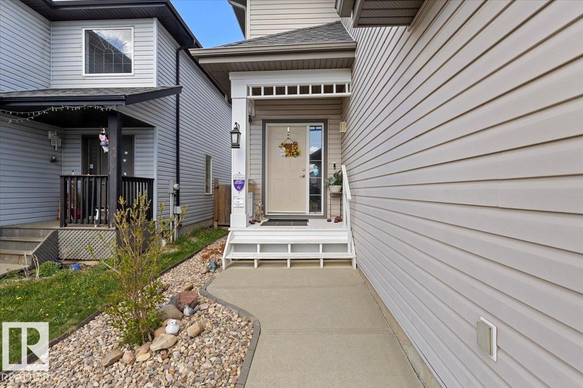 Front entrance featuring a covered porch, white column, and matching white railing - 3356 25 Ave, Edmonton, AB - Outdoor