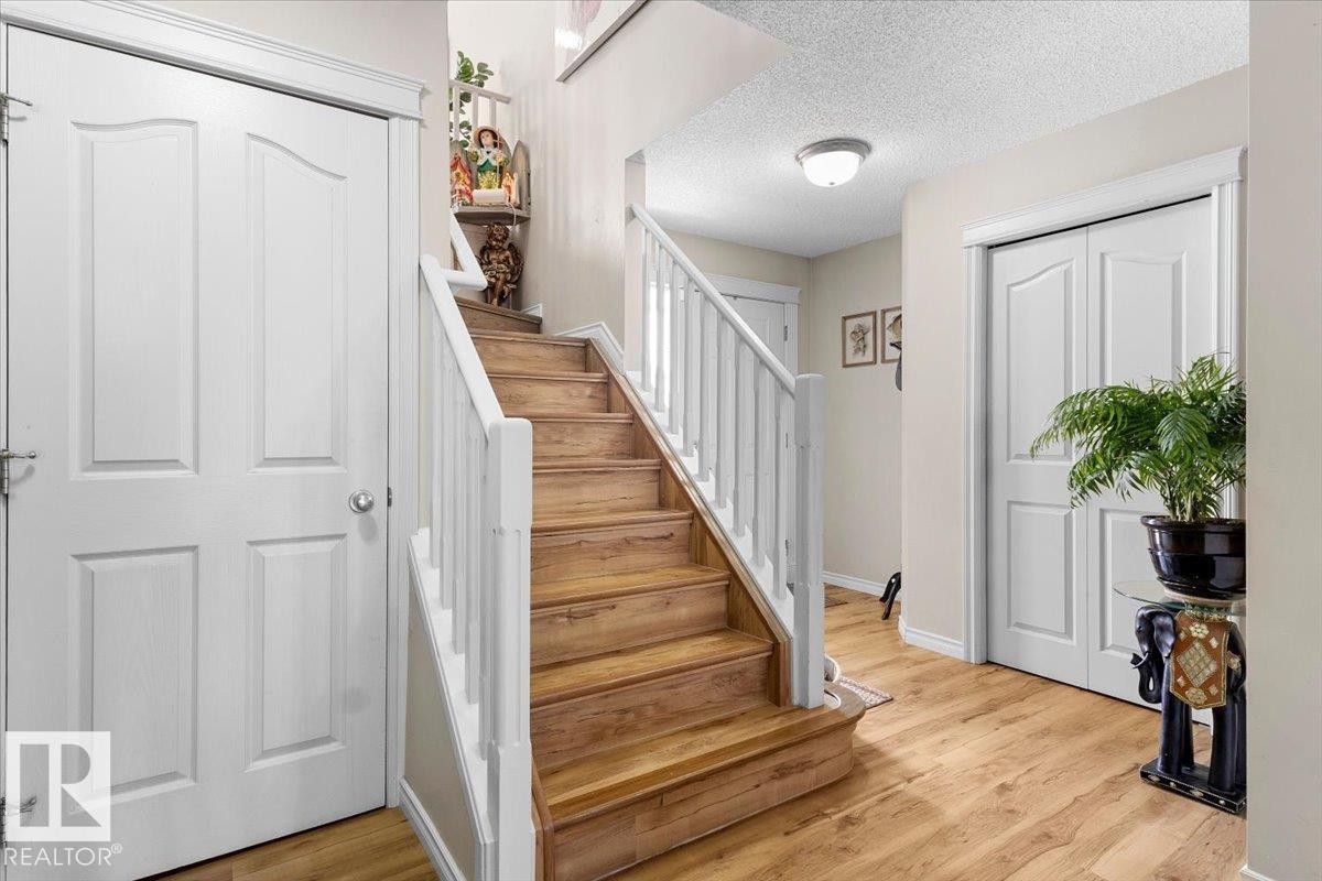 Staircase with wood-finish treads and white risers - 3356 25 Ave, Edmonton, AB - Indoor Photo Showing Other Room