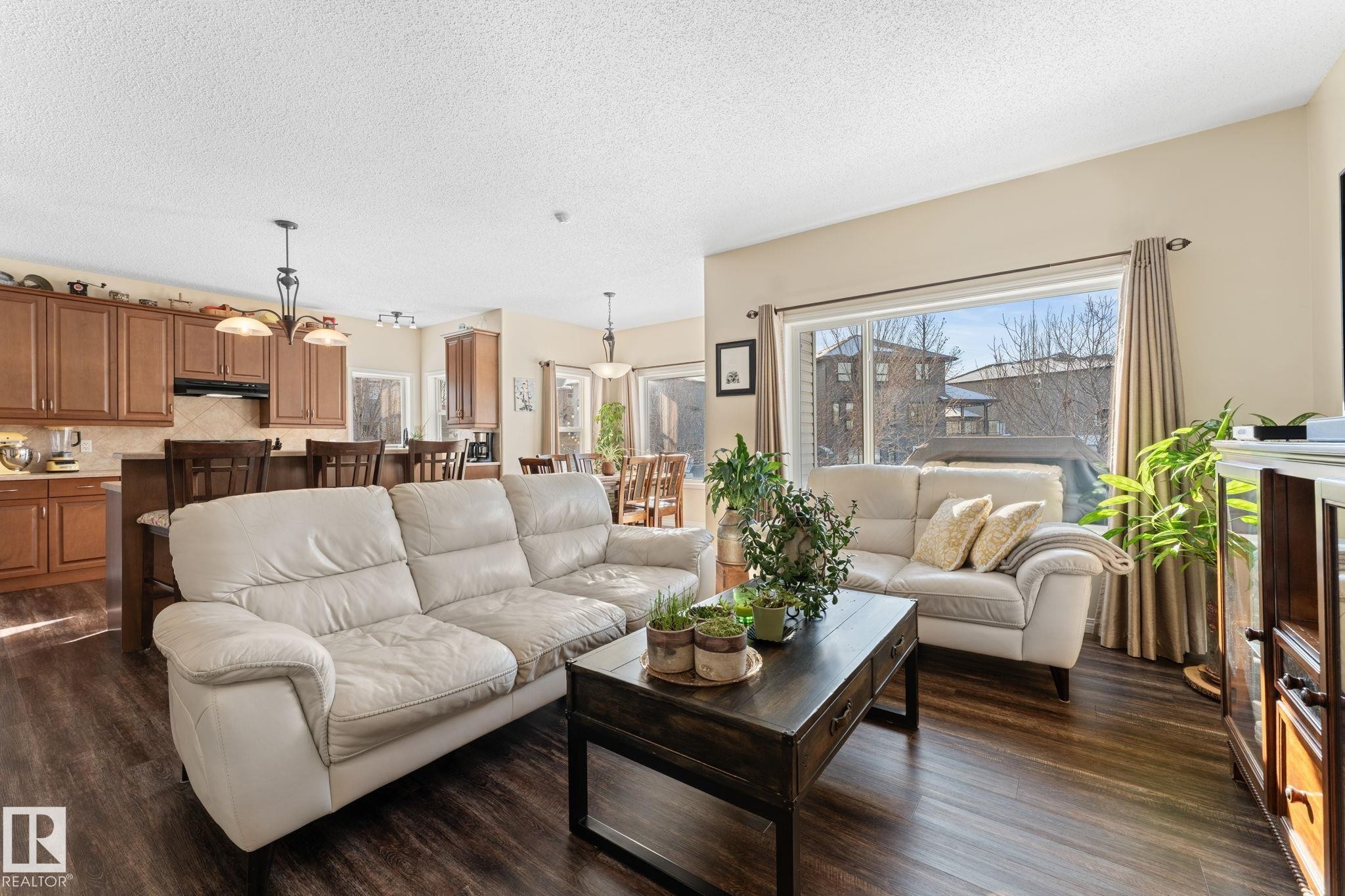 Open-concept living space featuring wood-finish flooring, a large picture window, and recessed lighting - 112 Lakeland Point(E), Beaumont, AB - Indoor Photo Showing Living Room