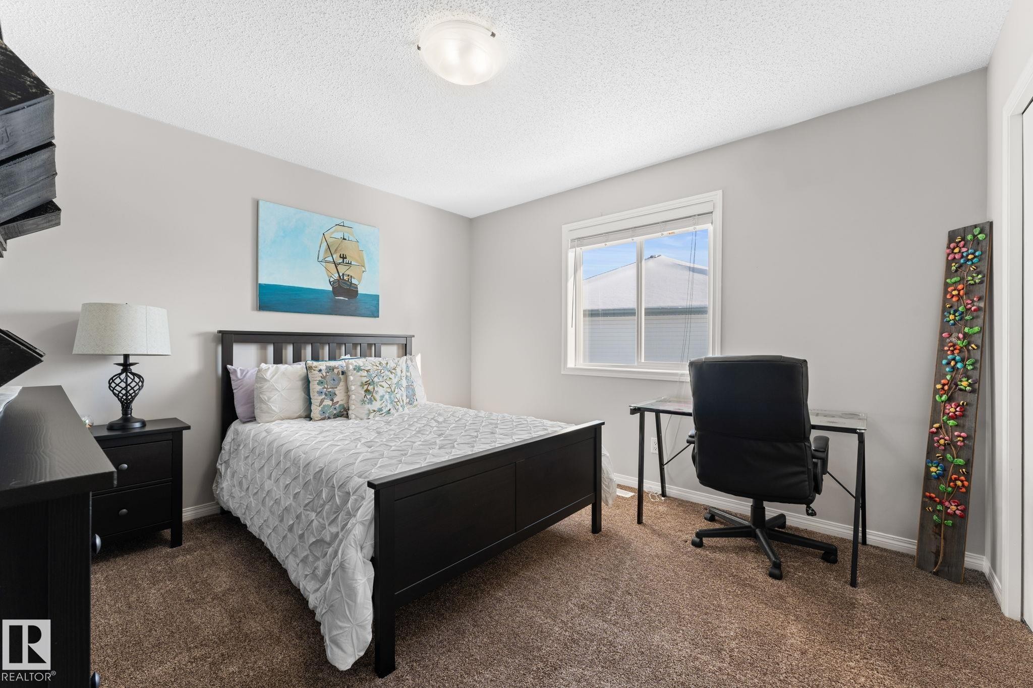 Bedroom featuring a neutral wall color, carpeted flooring, a window with white trim, and a ceiling-mounted light fixture - 112 Lakeland Point(E), Beaumont, AB - Indoor Photo Showing Bedroom