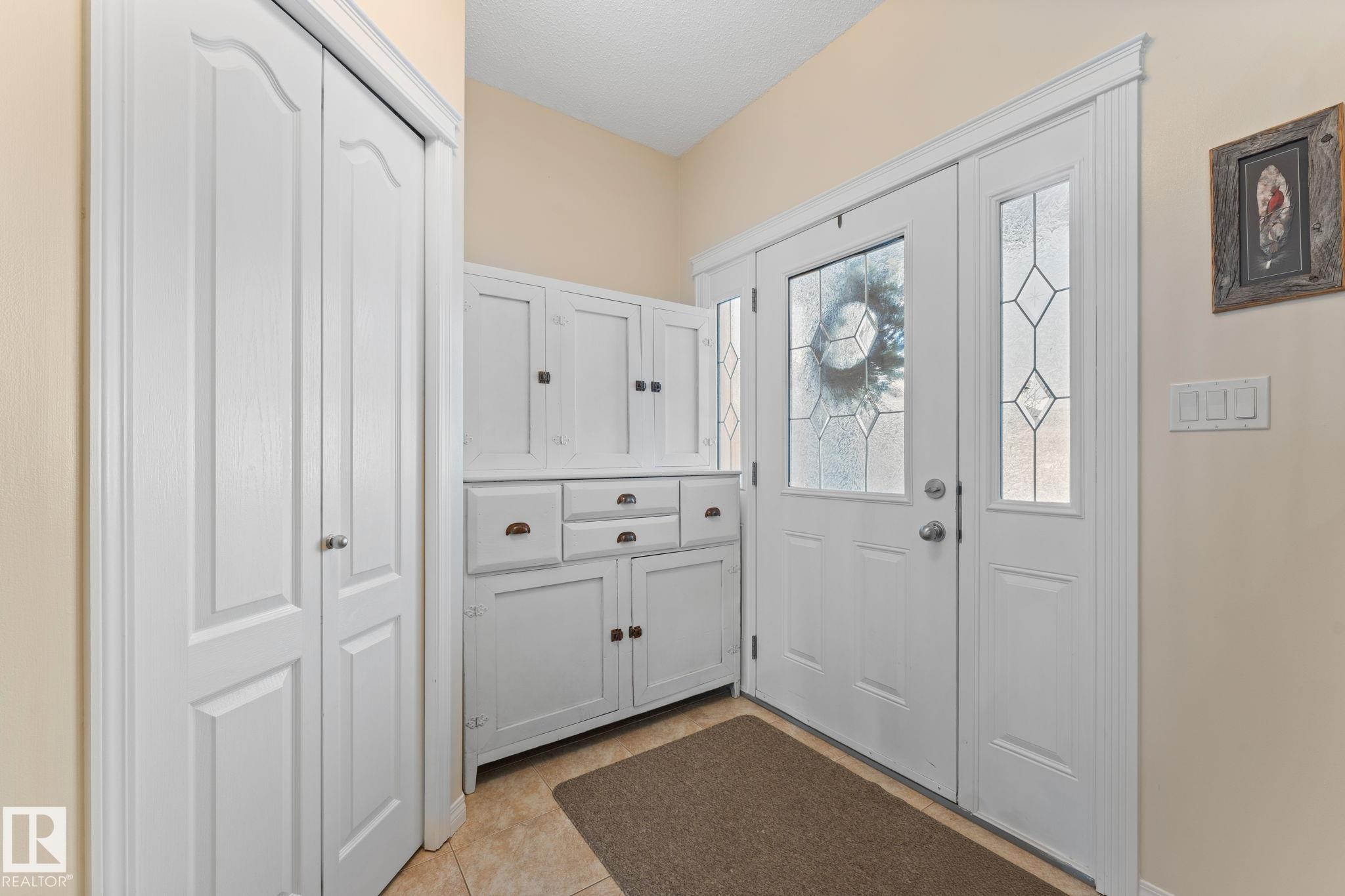 Entryway featuring a decorative frosted glass front door and side panel - 112 Lakeland Point(E), Beaumont, AB - Indoor Photo Showing Other Room