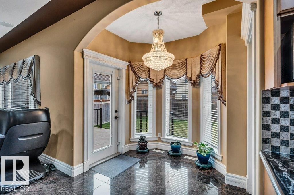 Bay window area with polished dark tile flooring and a multi-tiered crystal chandelier - 816 Wildwood Crescent, Edmonton, AB - Photo Showing Other Room