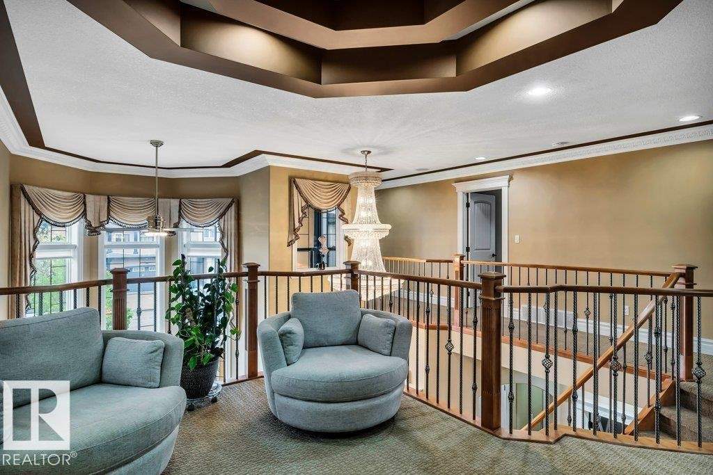 Upper-level landing featuring a coffered ceiling with recessed lighting, ornate chandelier, decorative window treatments, and wrought iron balusters with wood handrails - 816 Wildwood Crescent, Edmonton, AB - Indoor