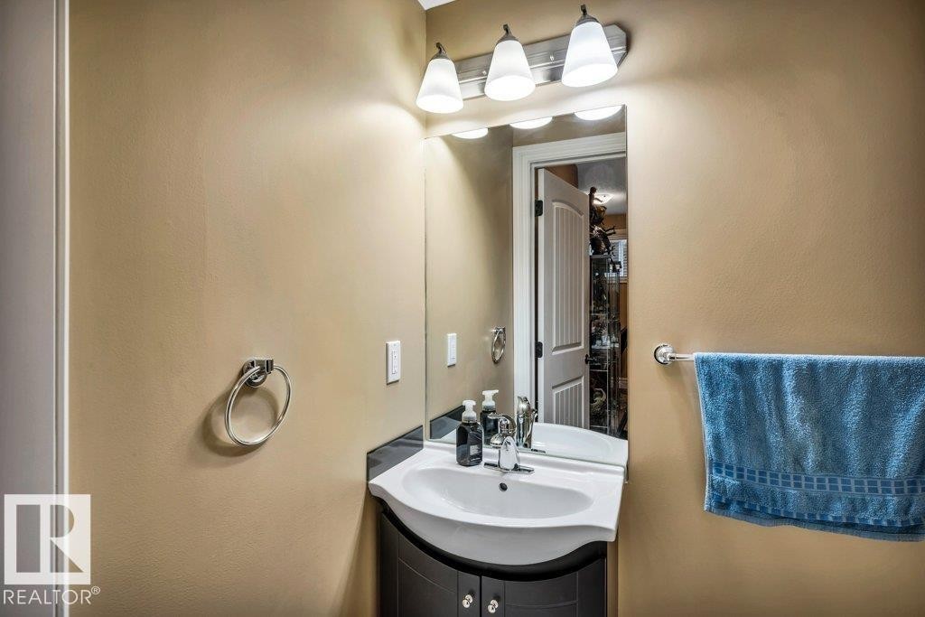 Bathroom vanity featuring a white sink basin, dark countertop, and base cabinetry with knob hardware - 816 Wildwood Crescent, Edmonton, AB - Indoor Photo Showing Bathroom