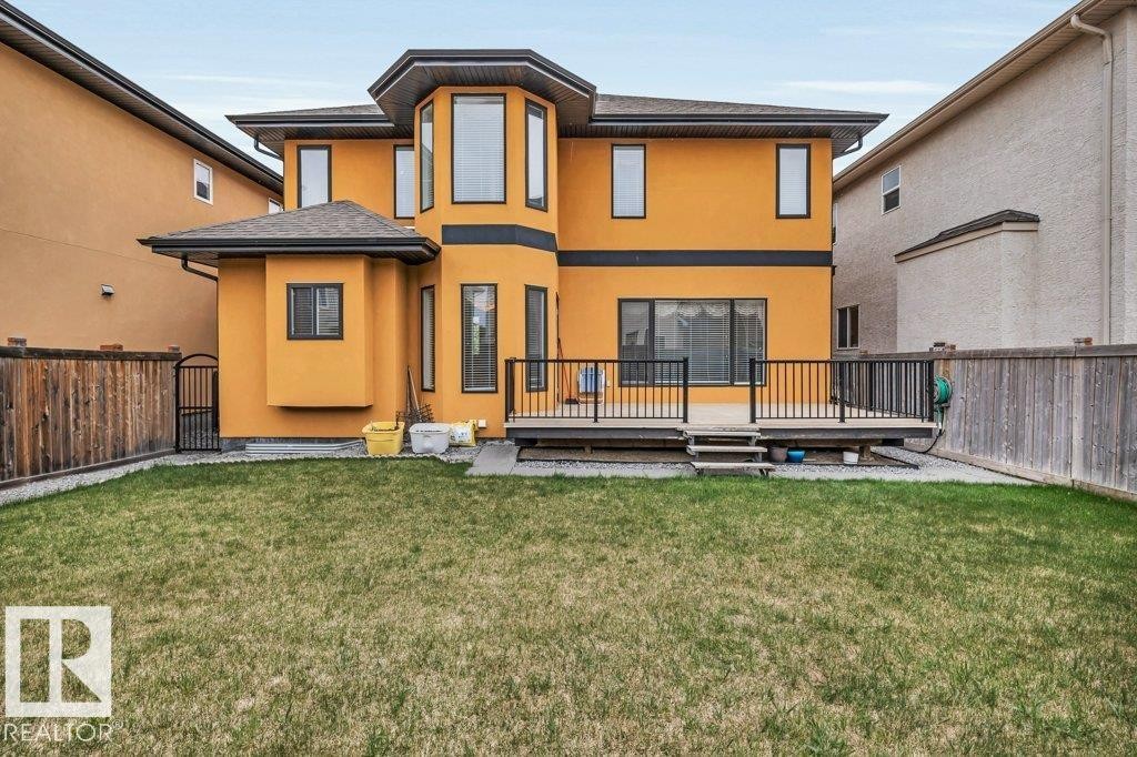 Rear exterior featuring a large elevated deck with dark railings, a bay window extension, and a stucco finish - 816 Wildwood Crescent, Edmonton, AB - Outdoor With Deck Patio Veranda