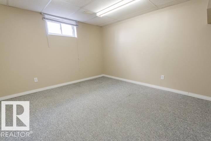 The room features a carpeted floor, light-colored walls, and a window with blinds - 10806 64 Avenue, Edmonton, AB - Indoor Photo Showing Other Room
