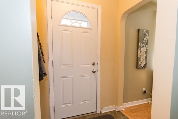 Entryway featuring a paneled door with an arched window, light-colored walls, and a tiled floor - 10806 64 Avenue, Edmonton, AB - Indoor Photo Showing Other Room