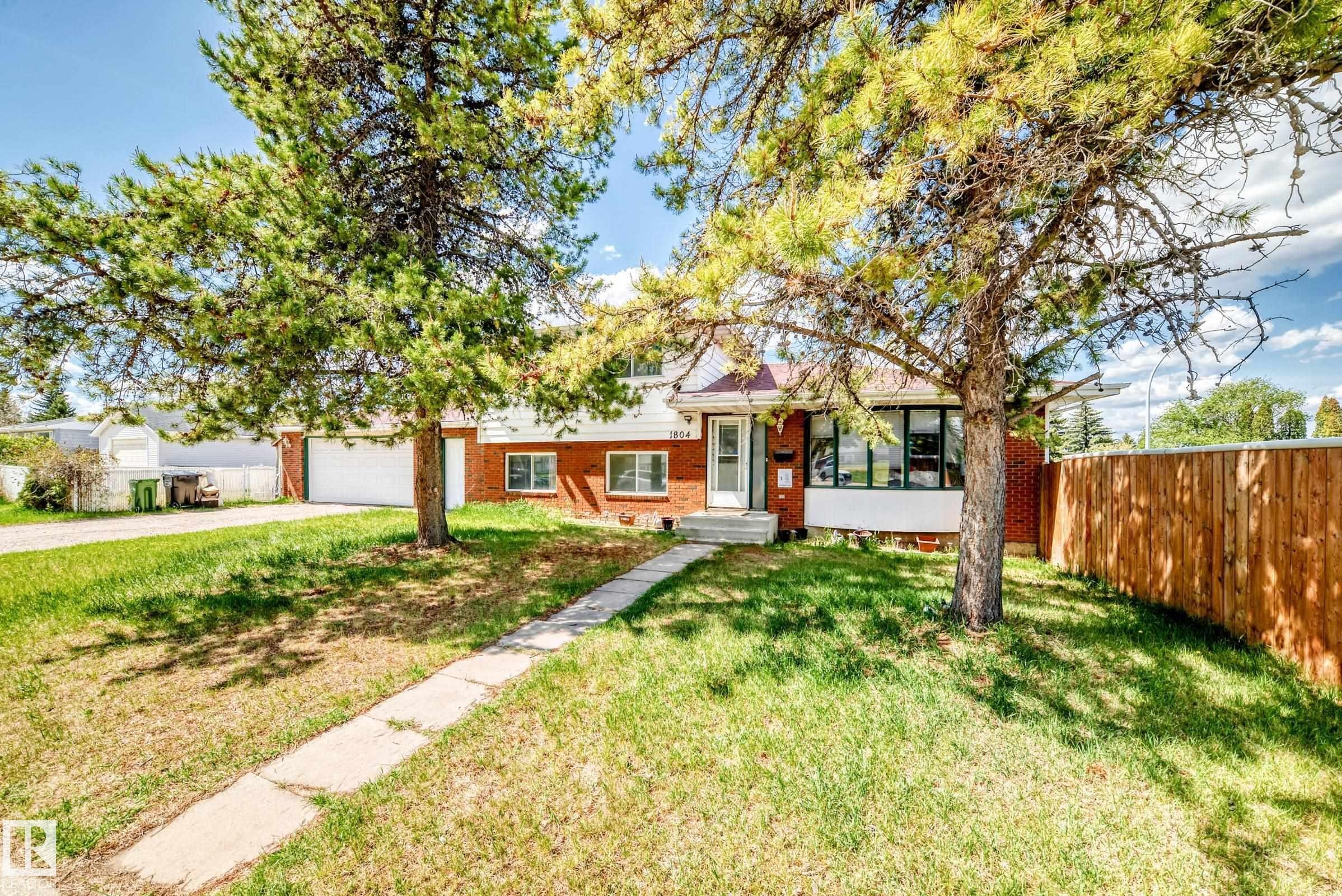 Brick and white siding exterior with a prominent front door and multiple windows - 1804 51 Street Nw, Edmonton, AB - Outdoor