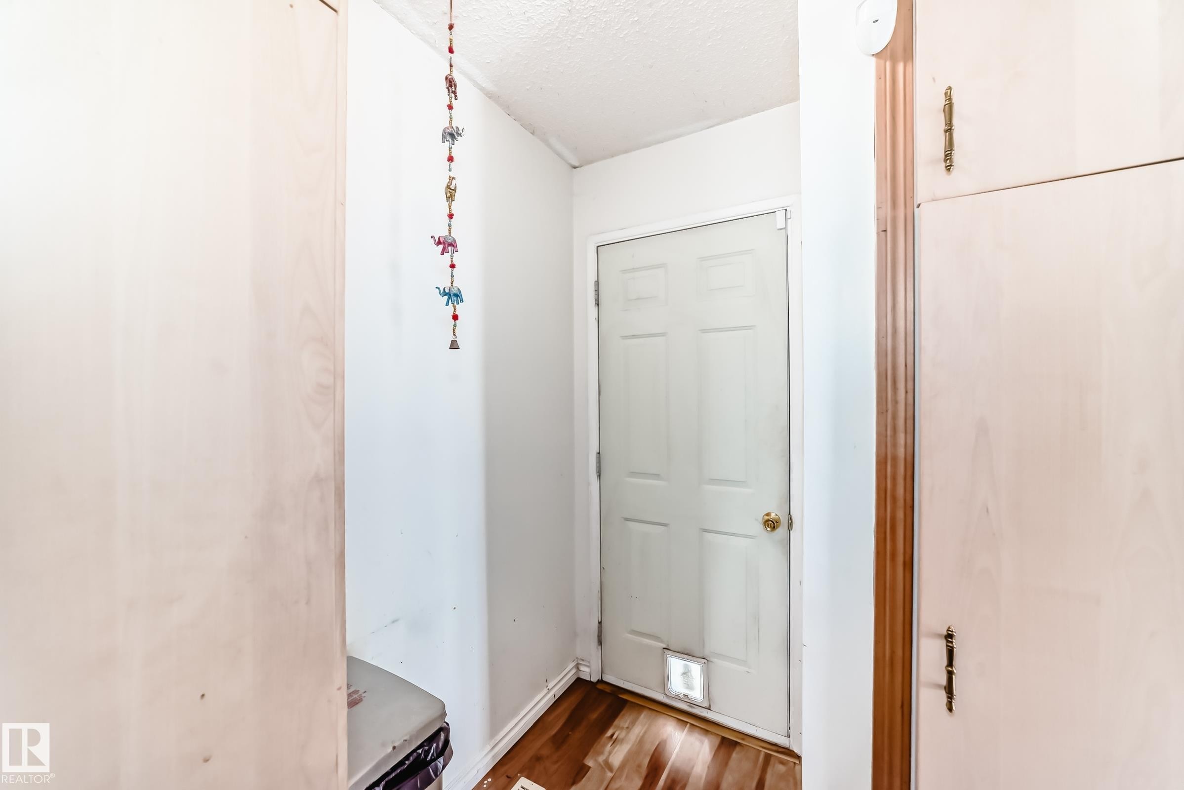 White paneled door with brass-toned hardware and a lower pet access panel - 1804 51 Street Nw, Edmonton, AB - Indoor Photo Showing Other Room