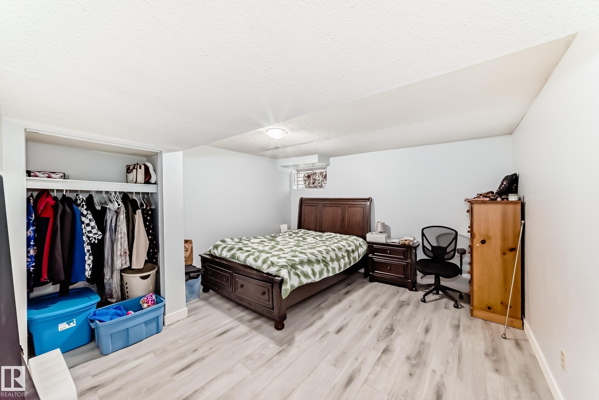Spacious room featuring light wood-finish flooring, white walls, and a built-in closet with shelving and hanging space - 1804 51 Street Nw, Edmonton, AB - Indoor Photo Showing Bedroom