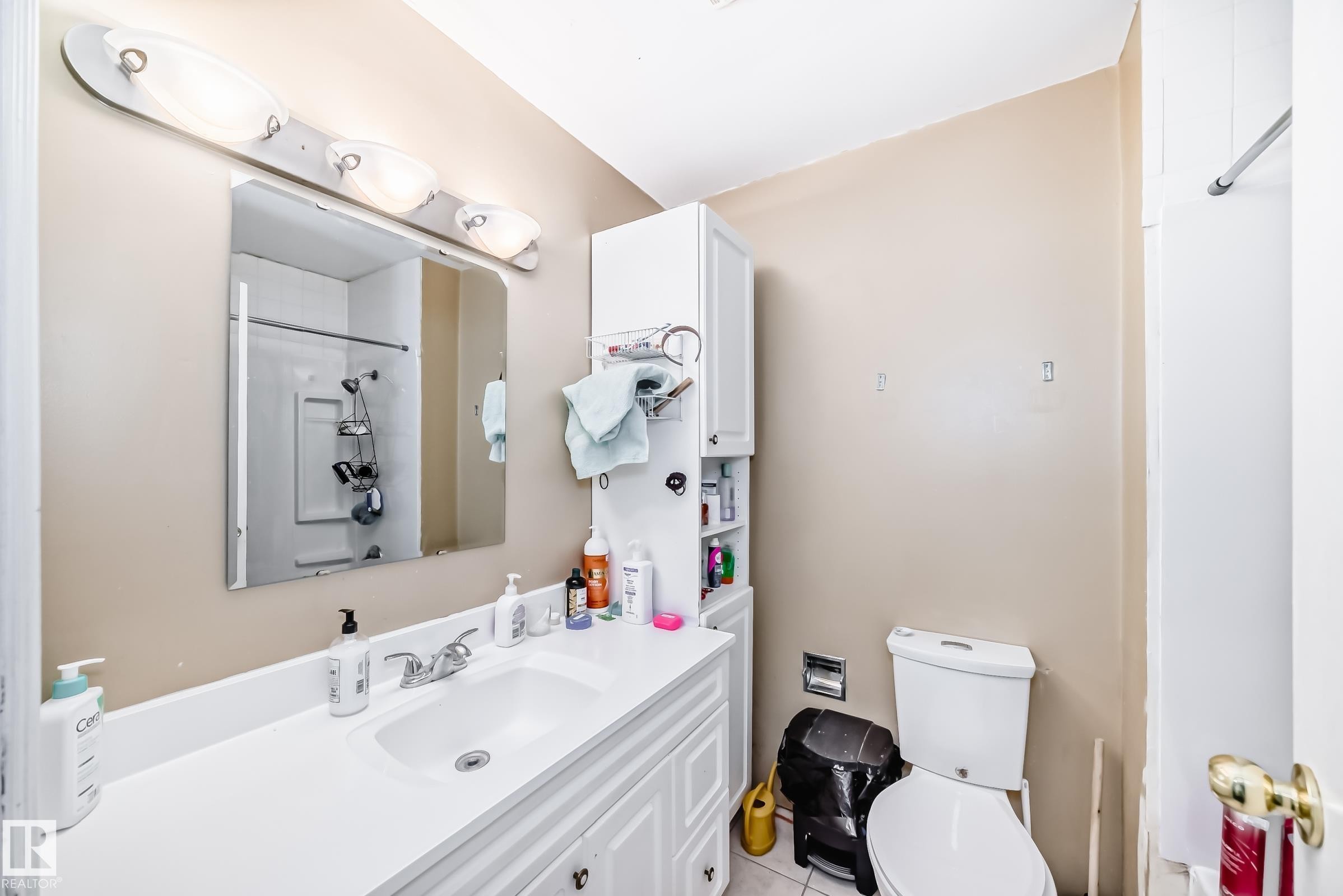 Bathroom featuring a white vanity with an integrated sink, wall-mounted mirror, and overhead light fixture - 1804 51 Street Nw, Edmonton, AB - Indoor Photo Showing Bathroom