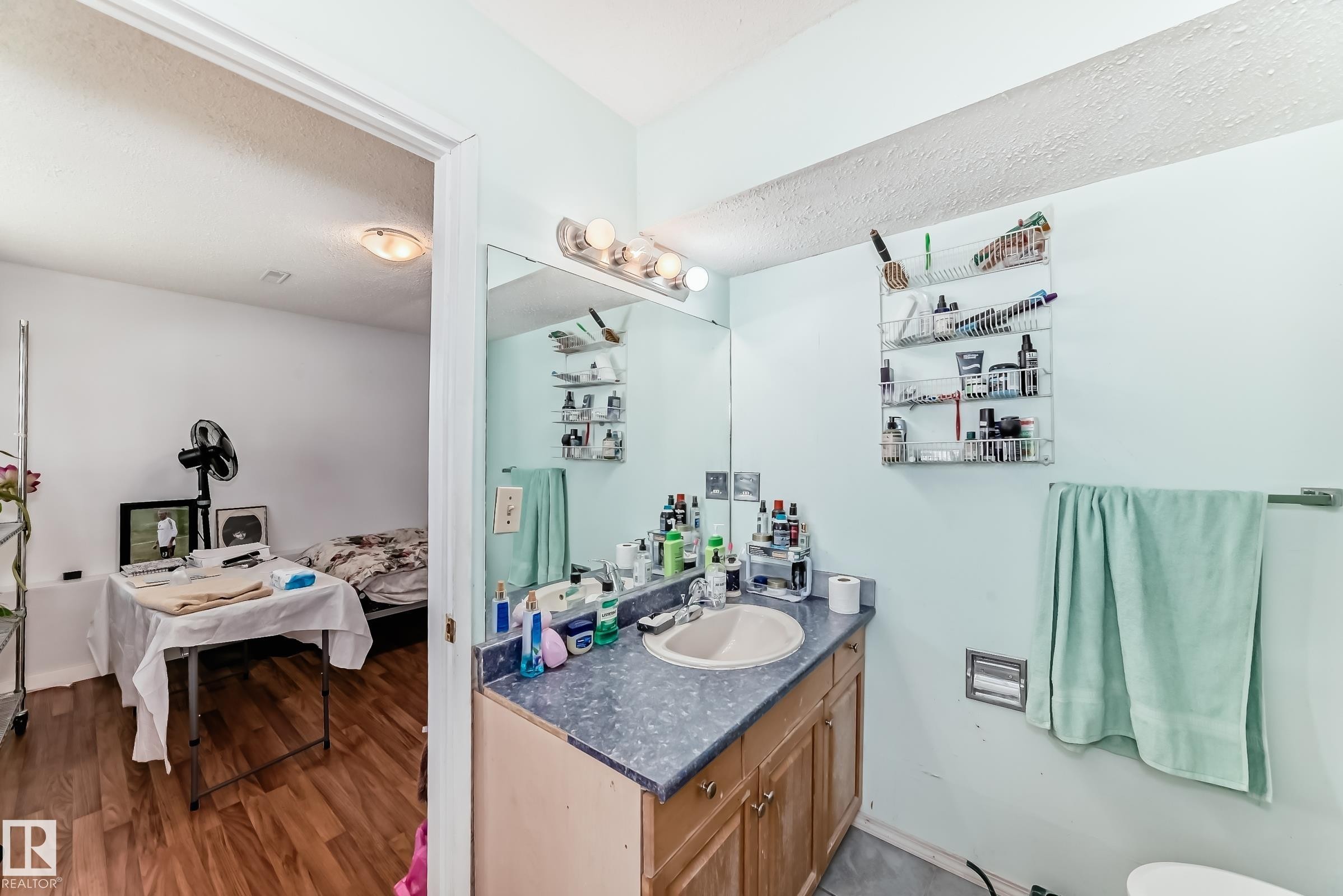 Bathroom featuring a wood-finish vanity with an integrated sink and a speckled countertop - 1804 51 Street Nw, Edmonton, AB - Indoor Photo Showing Bathroom