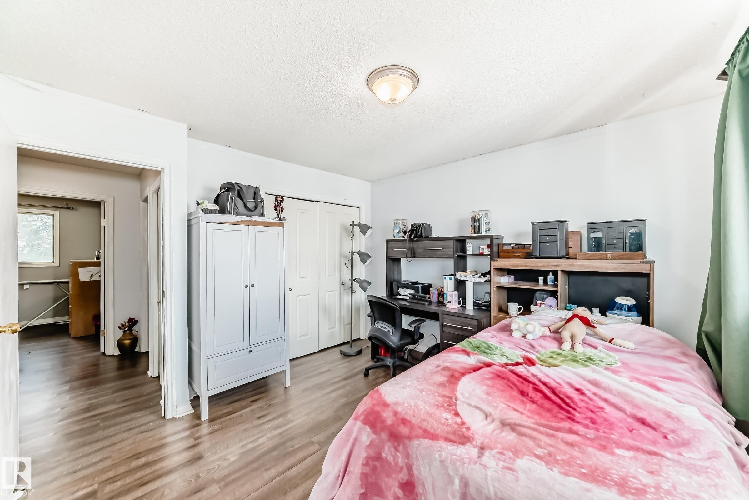 Spacious room featuring wood-finish flooring, white walls, and a ceiling-mounted light fixture - 1804 51 Street Nw, Edmonton, AB - Indoor Photo Showing Bedroom