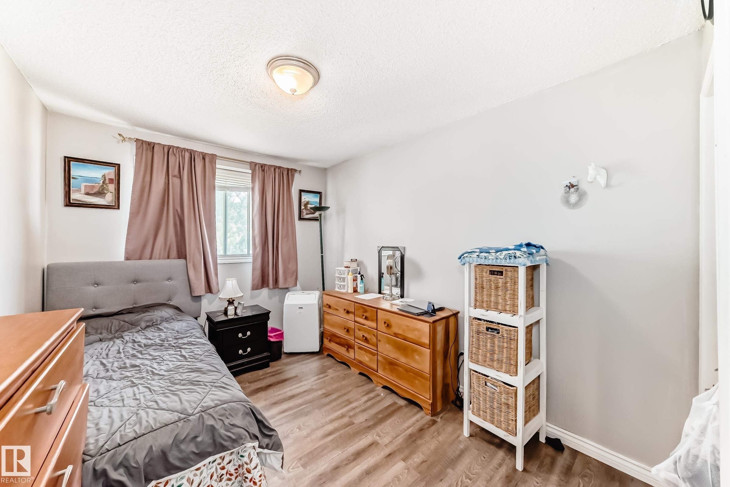 Bedroom with wood-finish flooring, a window featuring blinds and drapery, and a ceiling-mounted light fixture - 1804 51 Street Nw, Edmonton, AB - Indoor Photo Showing Bedroom