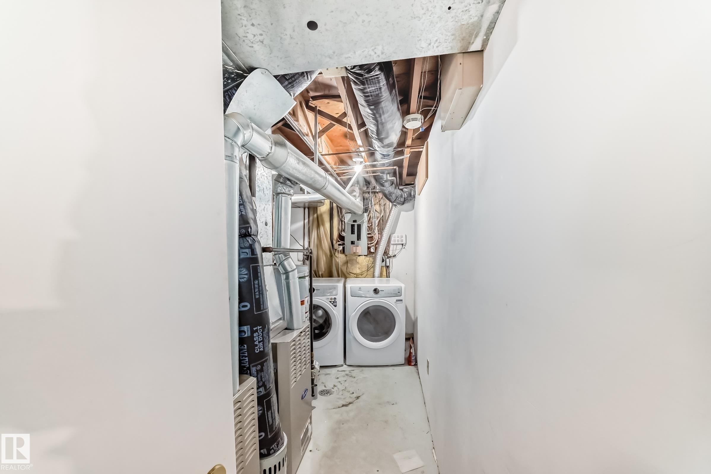 Dedicated utility area featuring a washer and dryer set, exposed ductwork, and ceiling joists - 1804 51 Street Nw, Edmonton, AB - Indoor Photo Showing Laundry Room