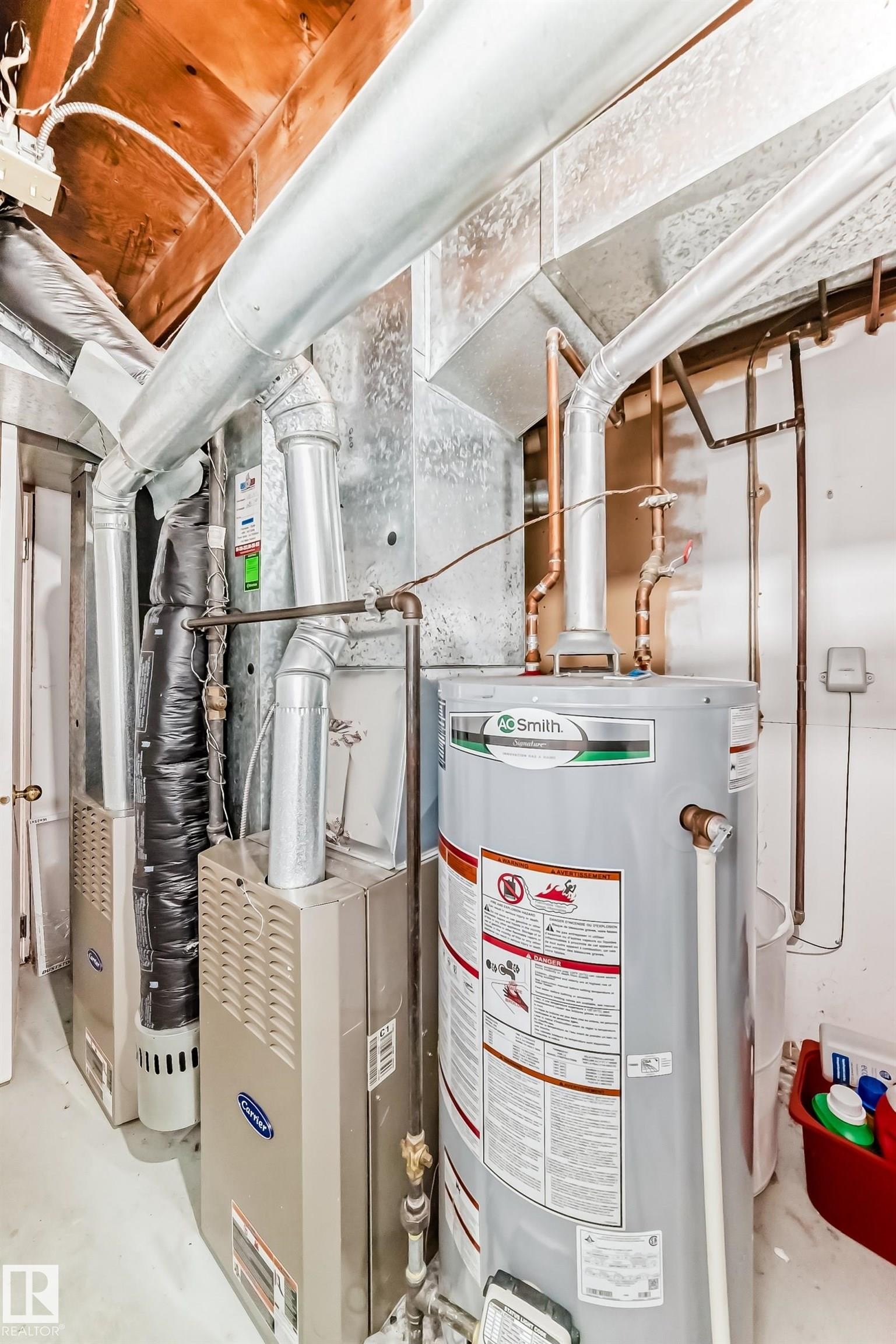 Mechanical room featuring a gas water heater, two forced-air furnaces, exposed ductwork, and copper plumbing - 1804 51 Street Nw, Edmonton, AB - Indoor Photo Showing Basement