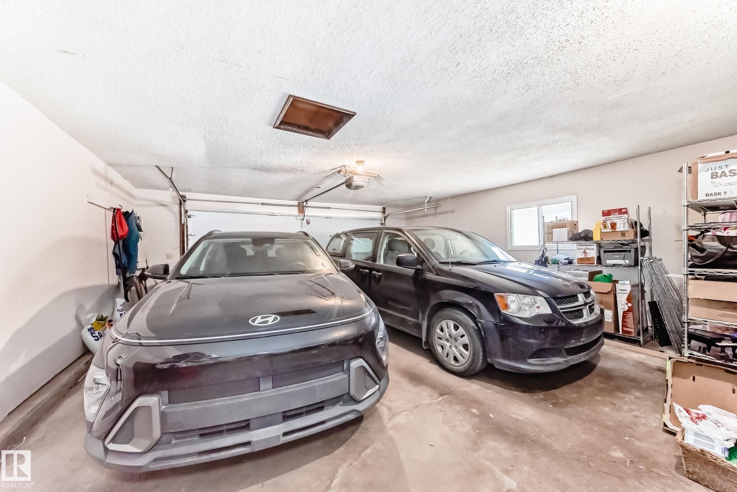 Attached two-car garage featuring a concrete floor, white walls, a single window, and an overhead light fixture - 1804 51 Street Nw, Edmonton, AB - Indoor Photo Showing Garage
