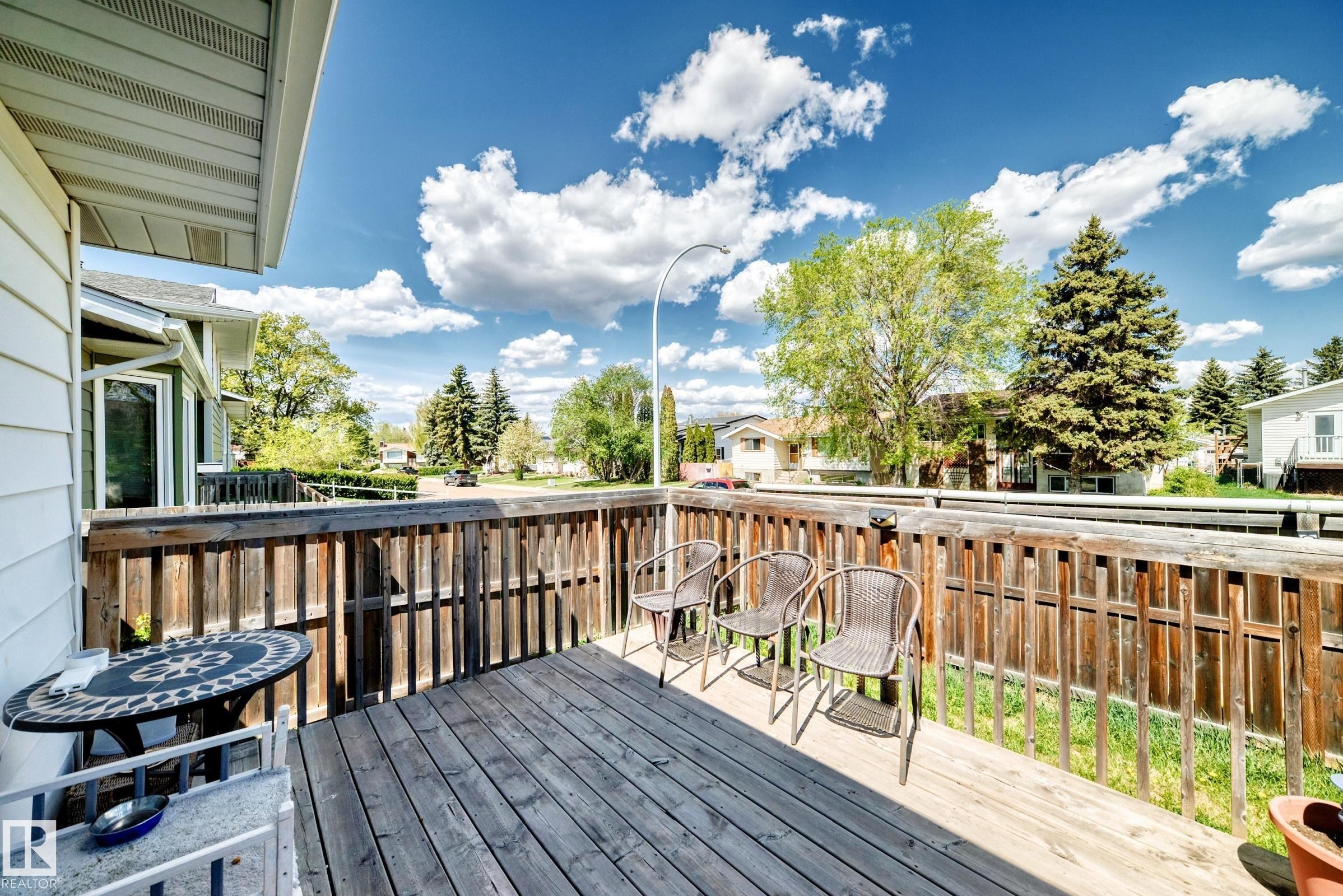 Spacious wood deck featuring a slatted wood railing, wood-finish flooring, and ample outdoor living area - 1804 51 Street Nw, Edmonton, AB - Outdoor With Exterior