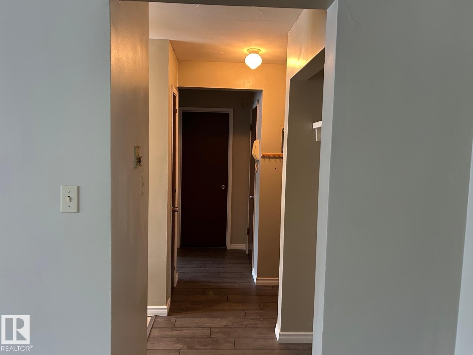 Hallway with wood-look flooring and a ceiling-mounted light fixture - #4 10164 150 St Nw, Edmonton, AB - Indoor Photo Showing Other Room