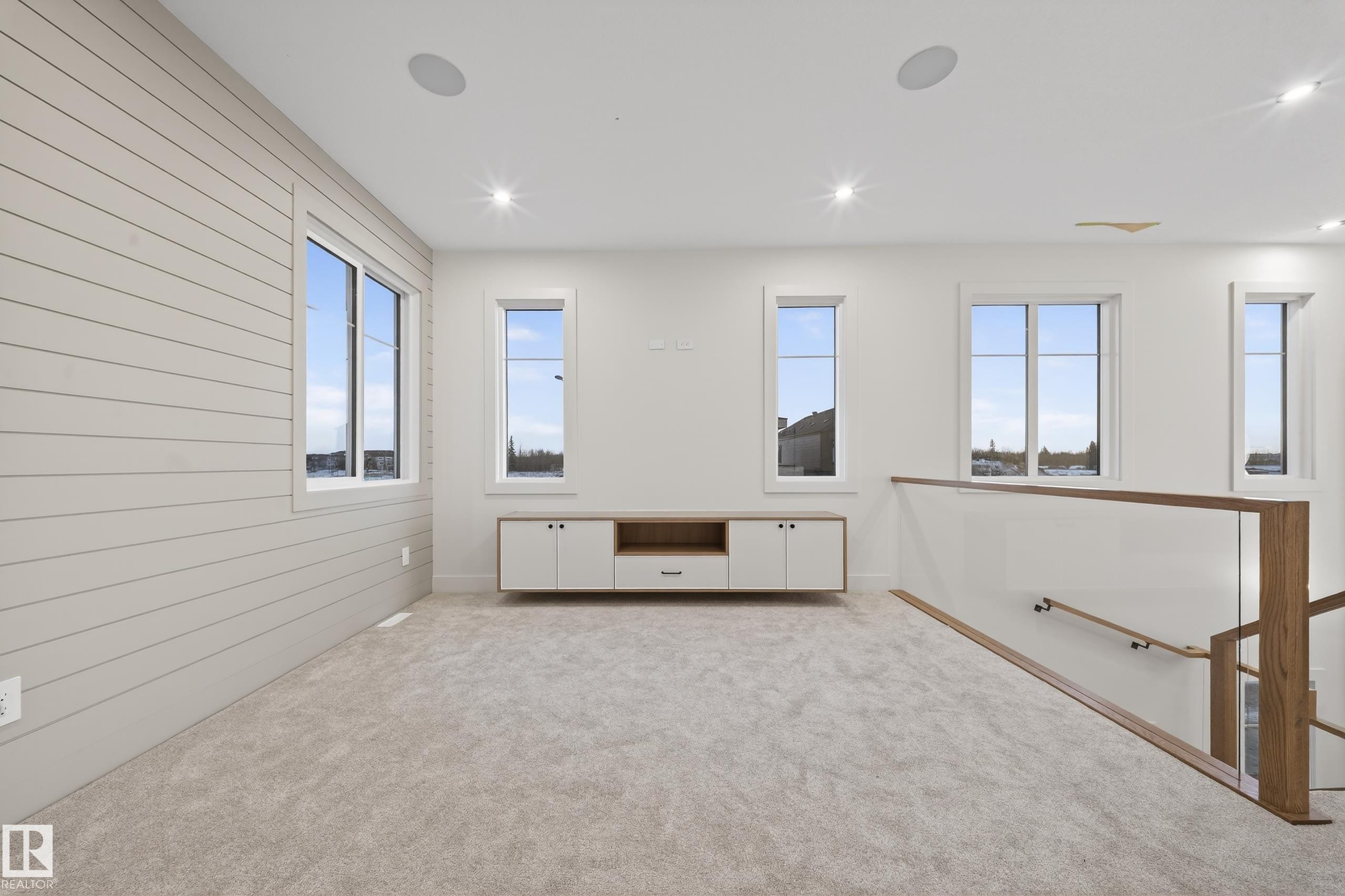Carpeted room featuring a shiplap accent wall and a built-in media console - 4276 Charles Close, Edmonton, AB - Indoor Photo Showing Other Room
