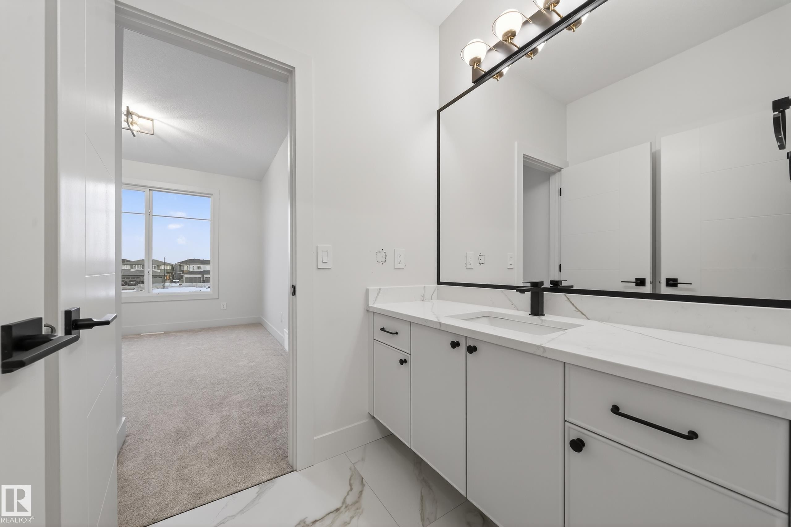 Modern vanity featuring a white countertop with integrated sink, matte black faucet, and coordinating cabinet hardware - 4276 Charles Close, Edmonton, AB - Indoor Photo Showing Bathroom