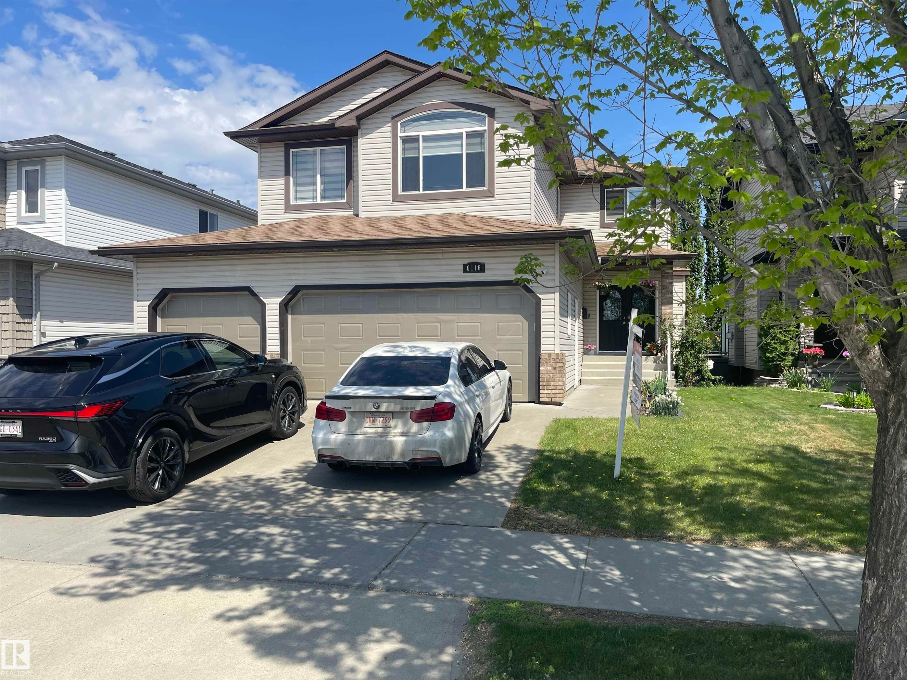 Two-story residence featuring light-colored siding, a prominent arched window, and an attached two-car garage - 6116 53 Avenue, Beaumont, AB - Outdoor With Exterior
