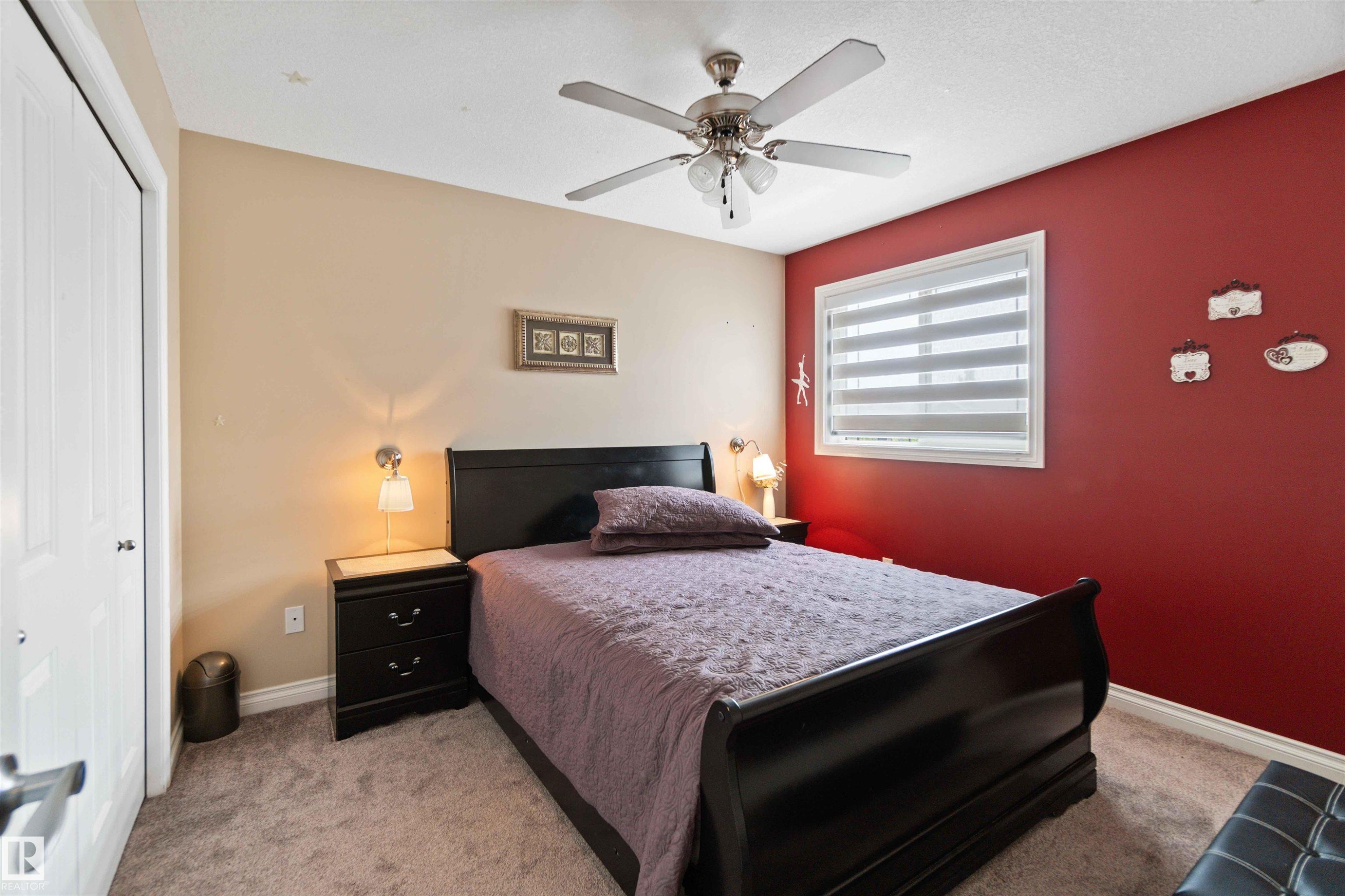 Room featuring two-tone walls, a white window with horizontal blinds, and a ceiling fan with integrated lighting - 6116 53 Avenue, Beaumont, AB - Indoor Photo Showing Bedroom