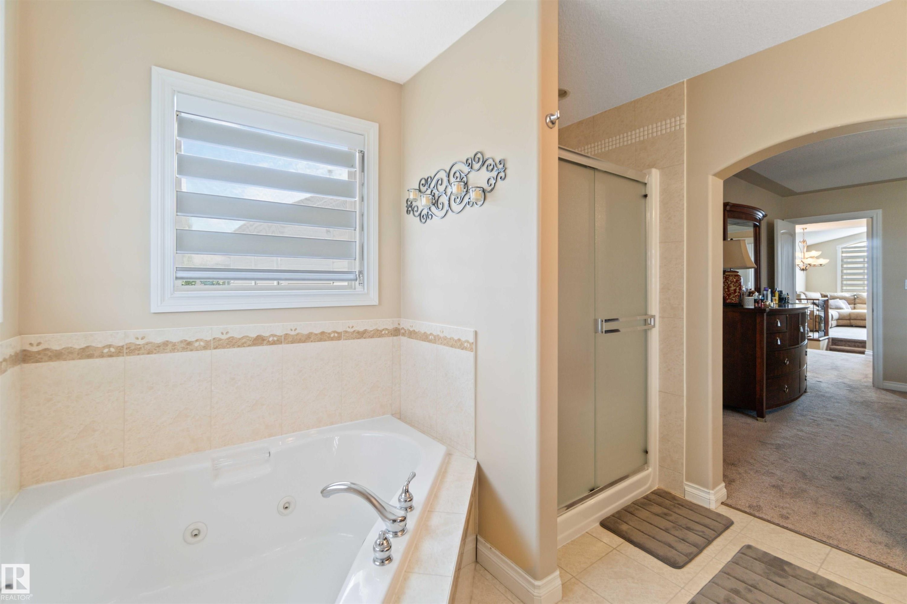 Corner jetted tub with chrome fixtures and a tiled surround - 6116 53 Avenue, Beaumont, AB - Indoor Photo Showing Bathroom