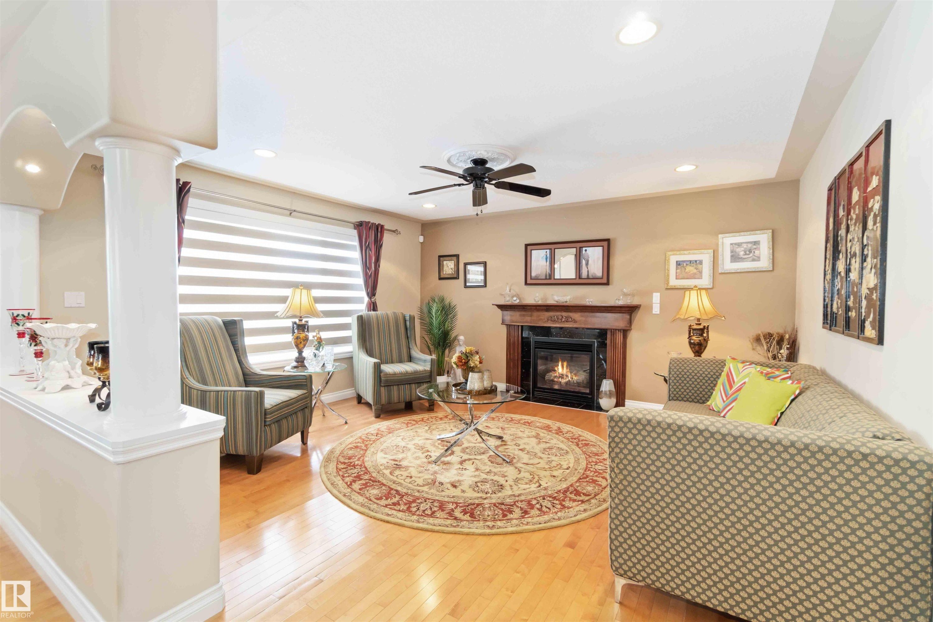 Living space featuring wood-finish flooring, recessed lighting, and a ceiling fan - 6116 53 Avenue, Beaumont, AB - Indoor Photo Showing Living Room With Fireplace