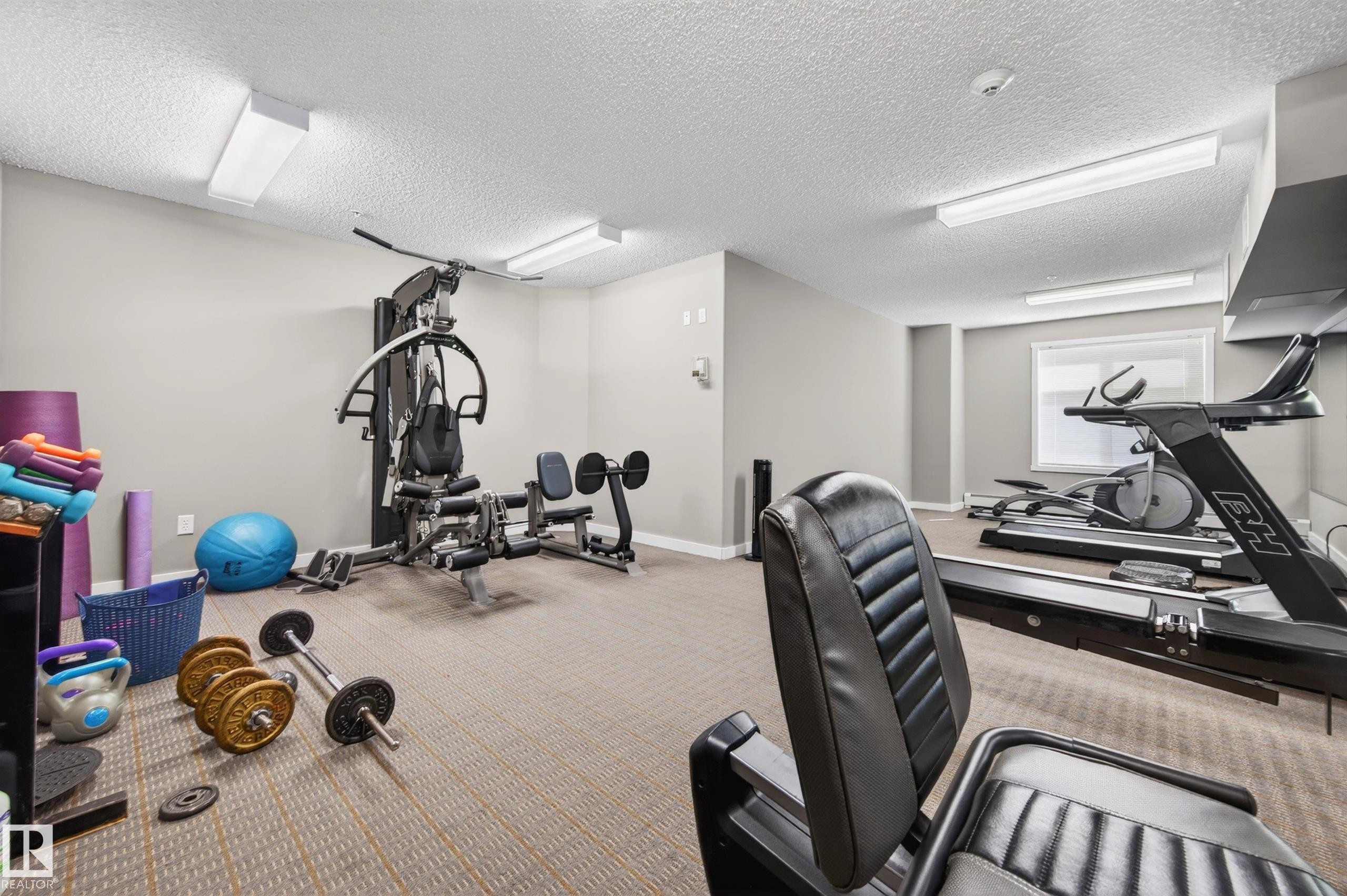 Carpeted exercise room featuring ample space, recessed lighting, and a window for natural light - 340 6076 Schonsee Way, Edmonton, AB - Indoor Photo Showing Gym Room