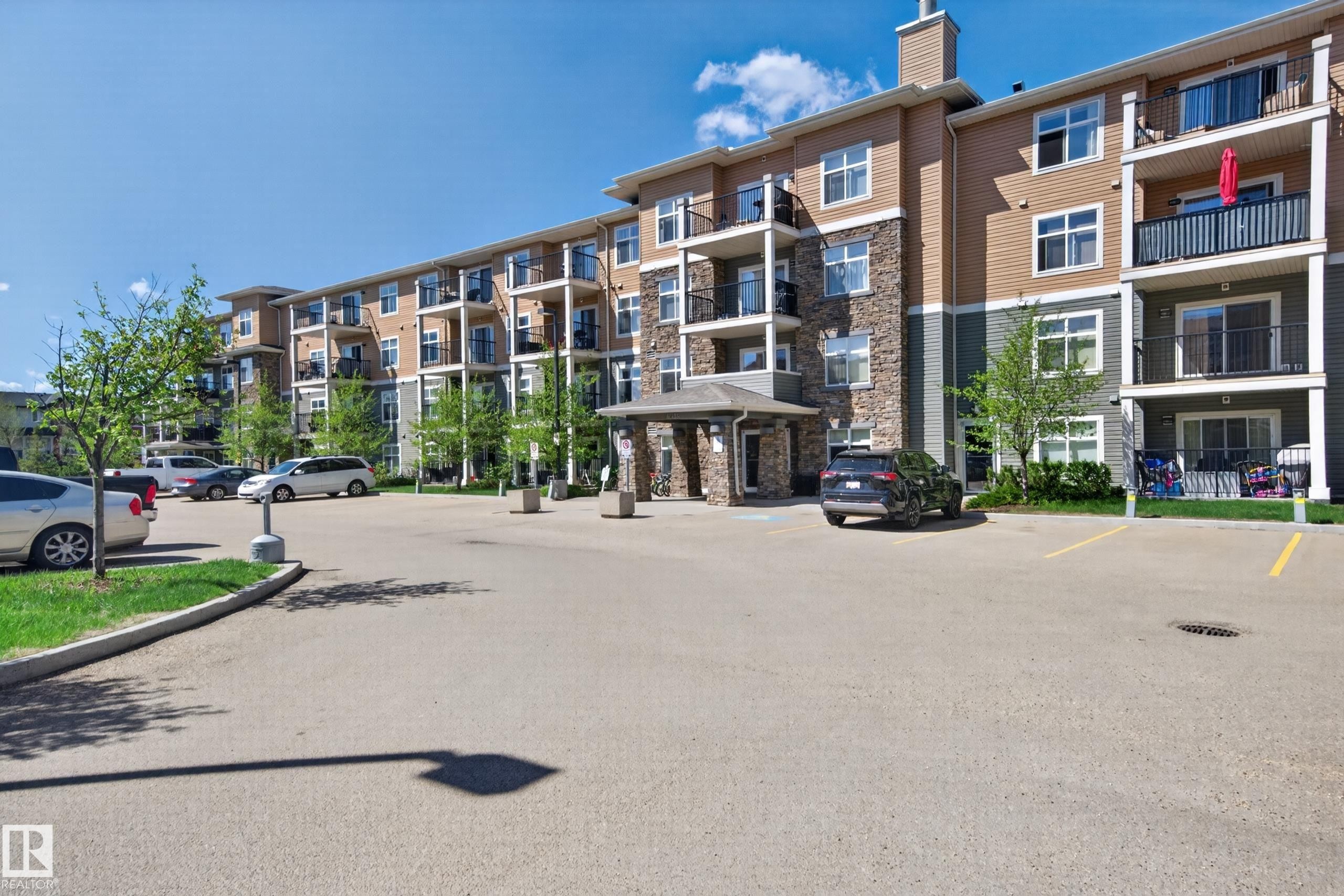 Multi-story residential building featuring a stone and siding exterior - 340 6076 Schonsee Way, Edmonton, AB - Outdoor With Balcony With Facade