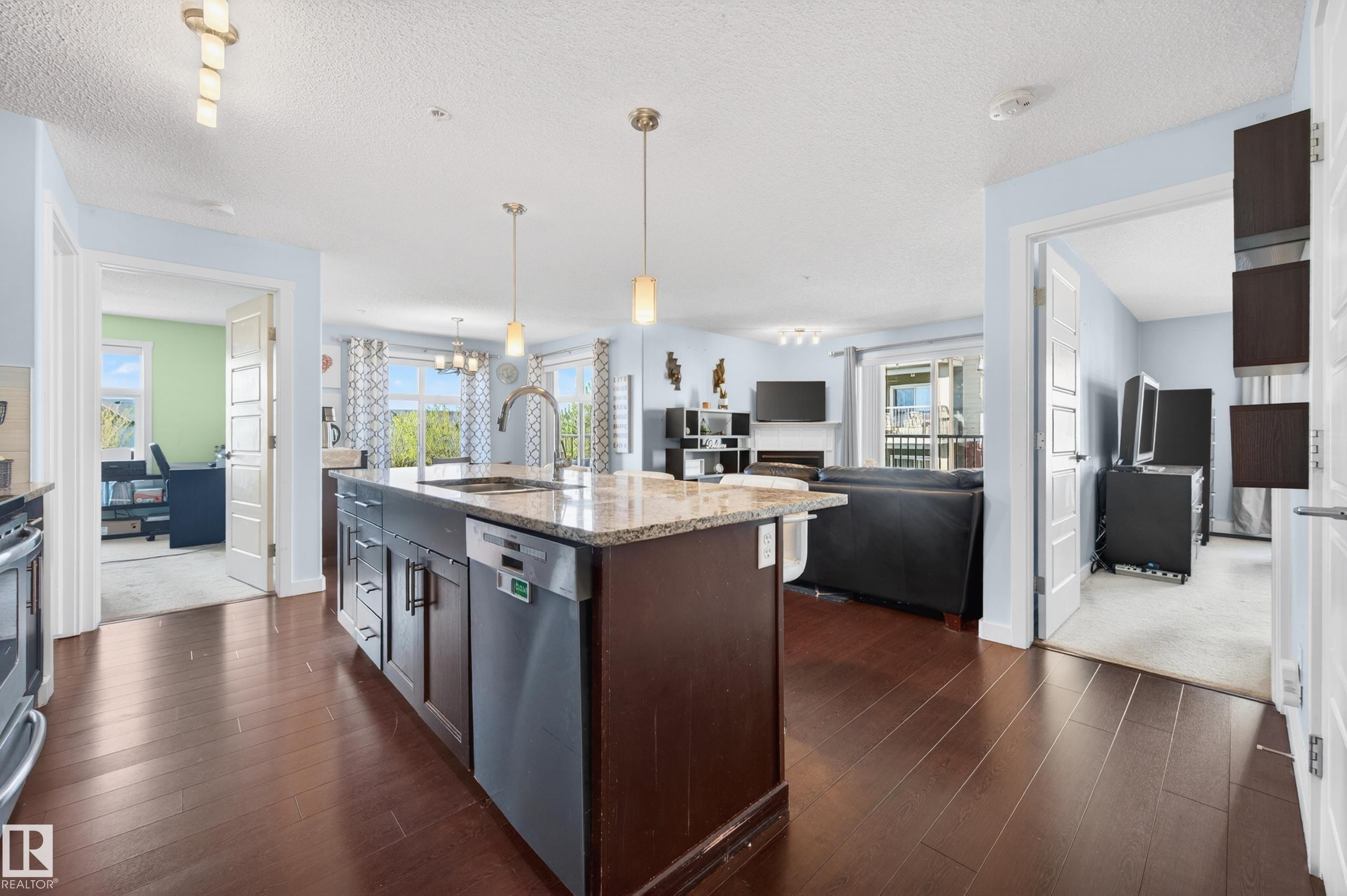 Kitchen island featuring a granite-style countertop, undermount sink, and stainless steel dishwasher - 340 6076 Schonsee Way, Edmonton, AB - Indoor Photo Showing Kitchen With Upgraded Kitchen