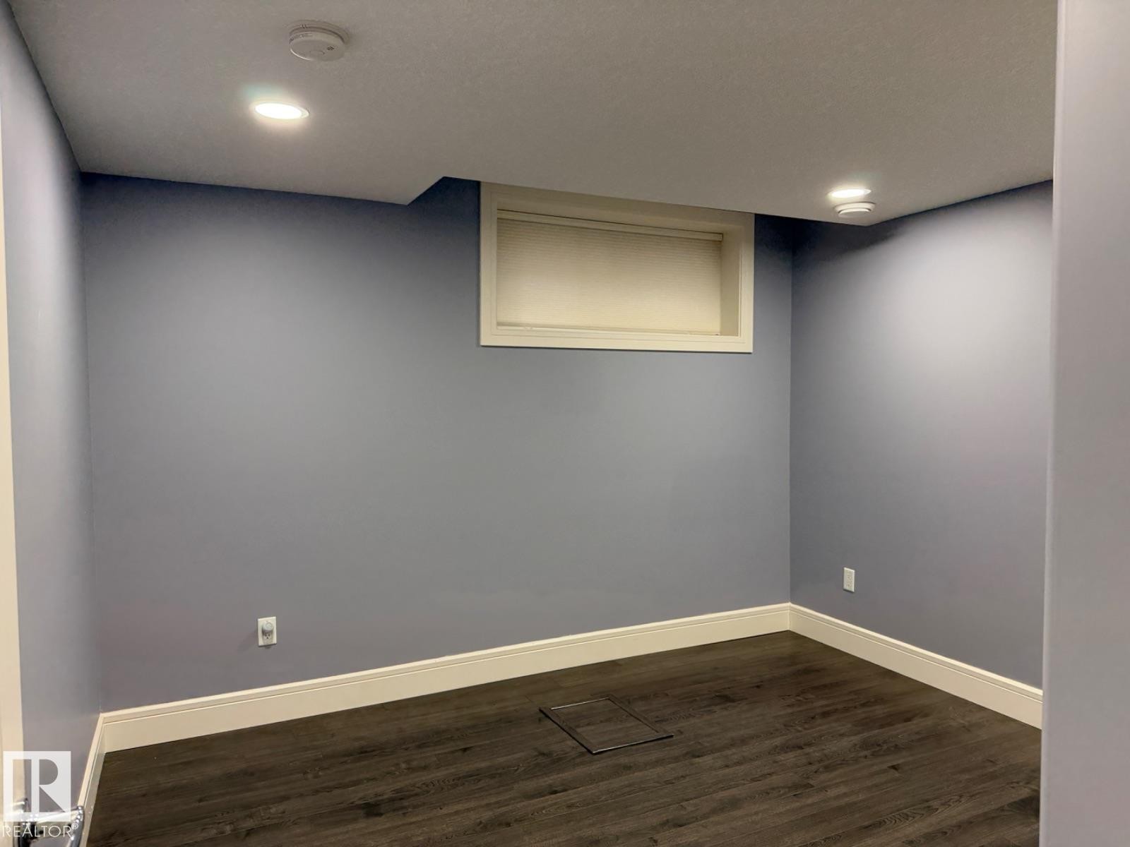 Room featuring recessed lighting, dark wood-finish flooring, and light blue walls - 648 178 Street, Edmonton, AB