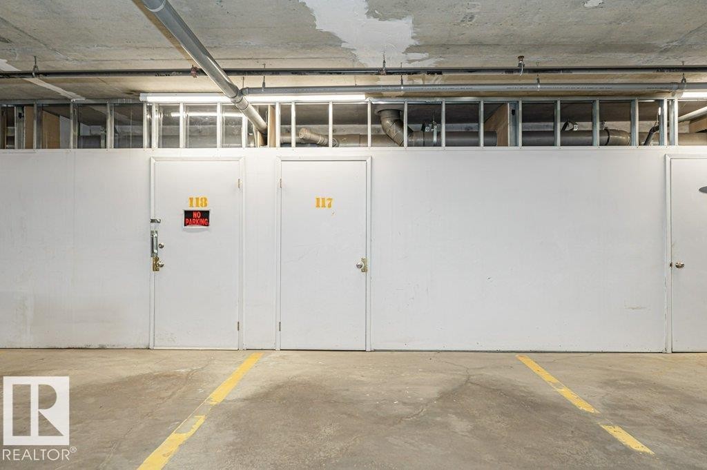 Concrete flooring with a yellow demarcation line - #145 10121 80 Av Nw, Edmonton, AB - Indoor Photo Showing Garage