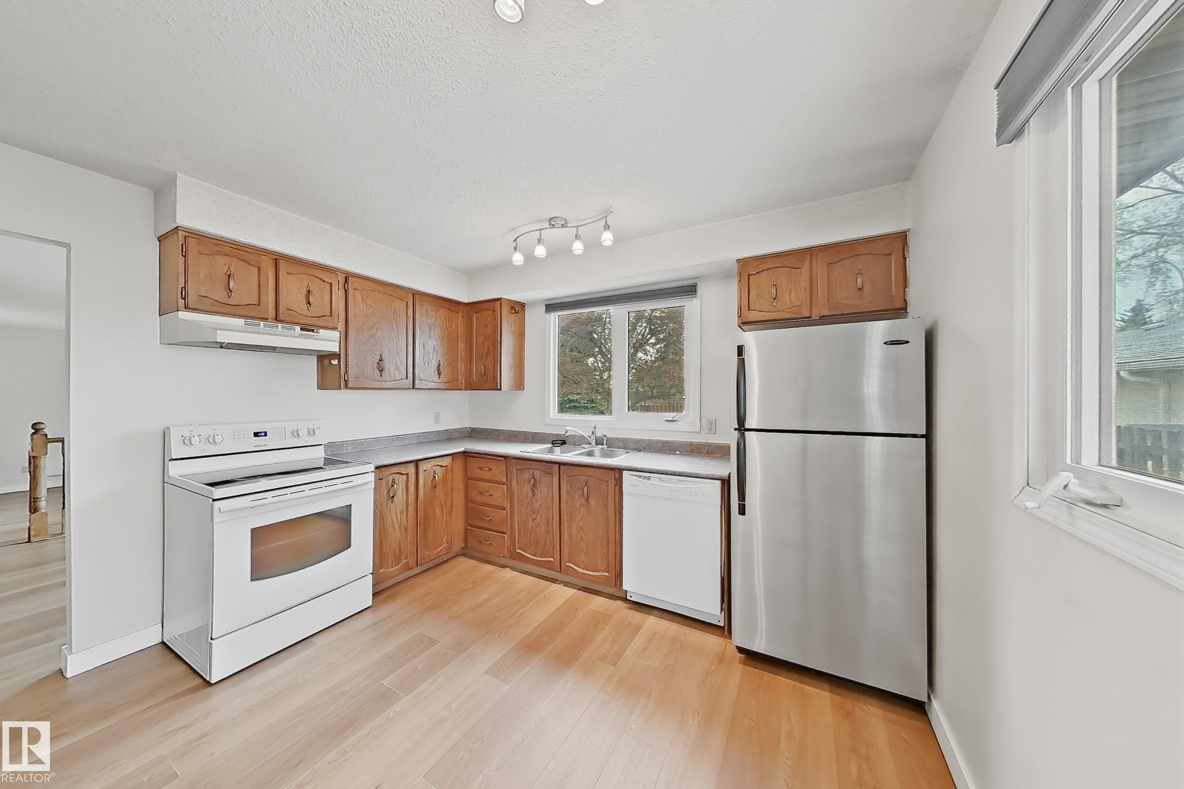 Kitchen with wood-finish cabinetry, light countertops, and light wood-finish flooring - 1731 51 Street, Edmonton, AB - Indoor Photo Showing Kitchen