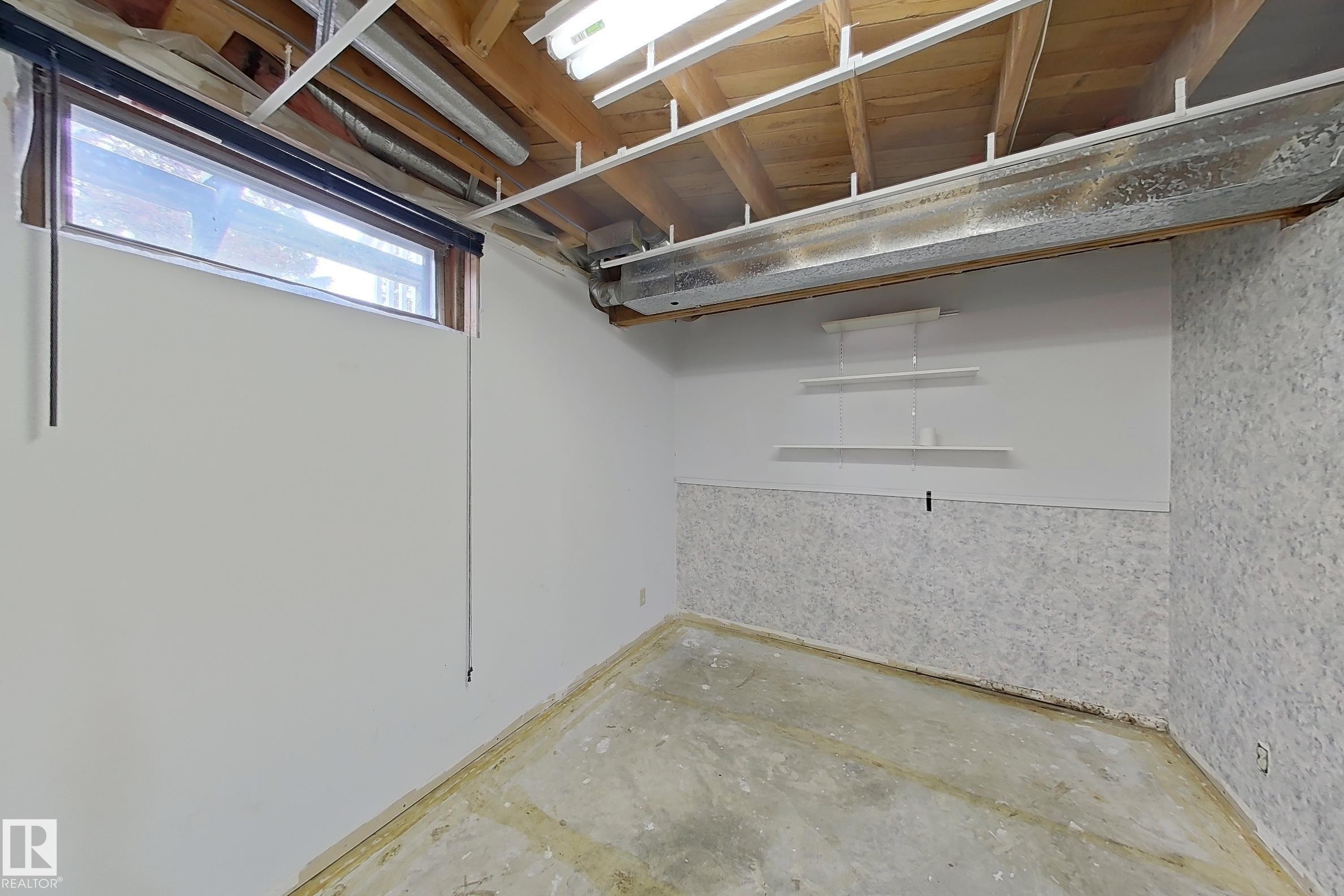 Interior space featuring exposed ceiling joists, overhead fluorescent lighting, and a concrete floor - 1731 51 Street, Edmonton, AB - Indoor Photo Showing Basement
