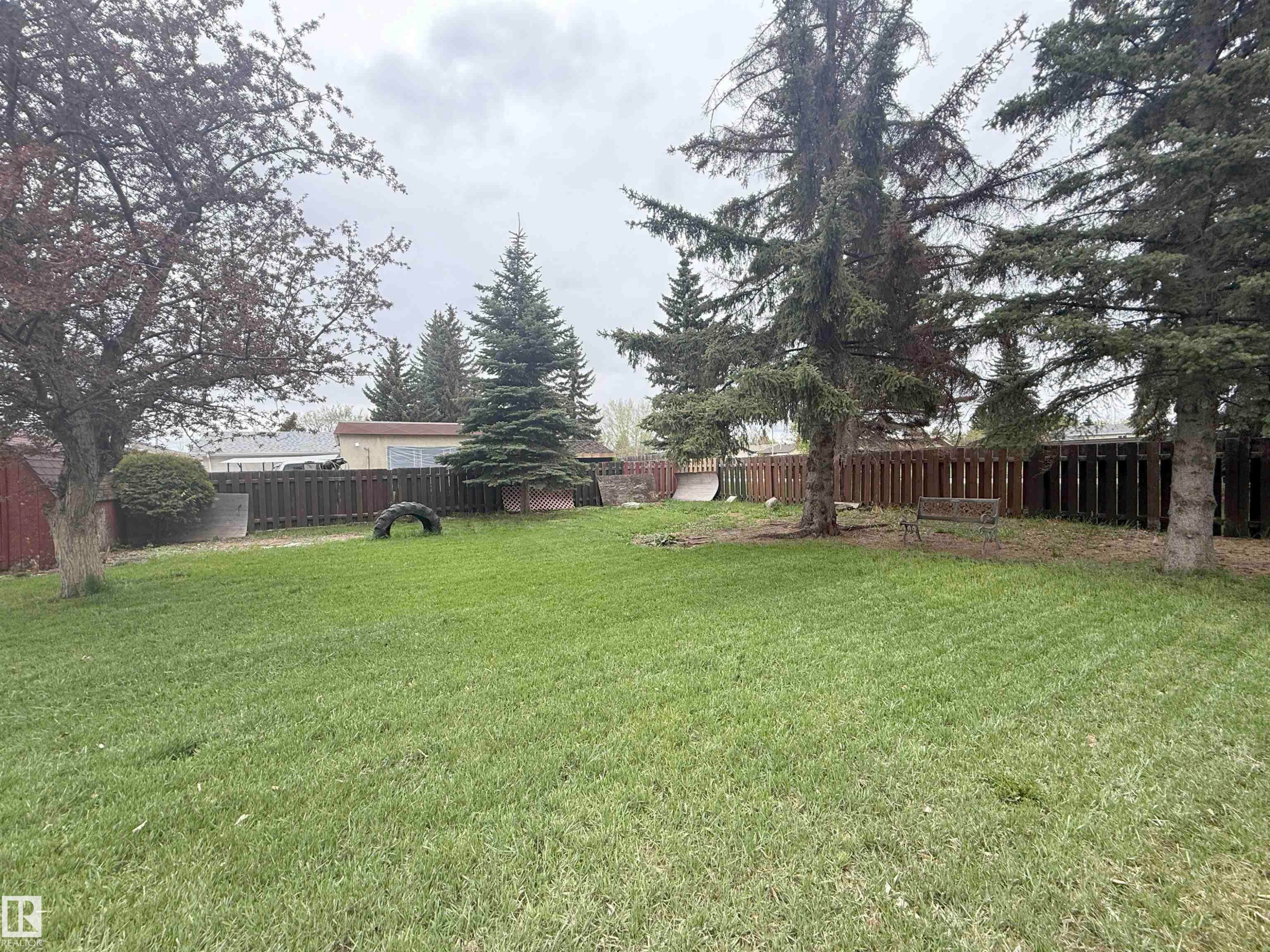 Expansive backyard featuring a manicured lawn, established mature trees, and a perimeter privacy fence - 1731 51 Street, Edmonton, AB - Outdoor
