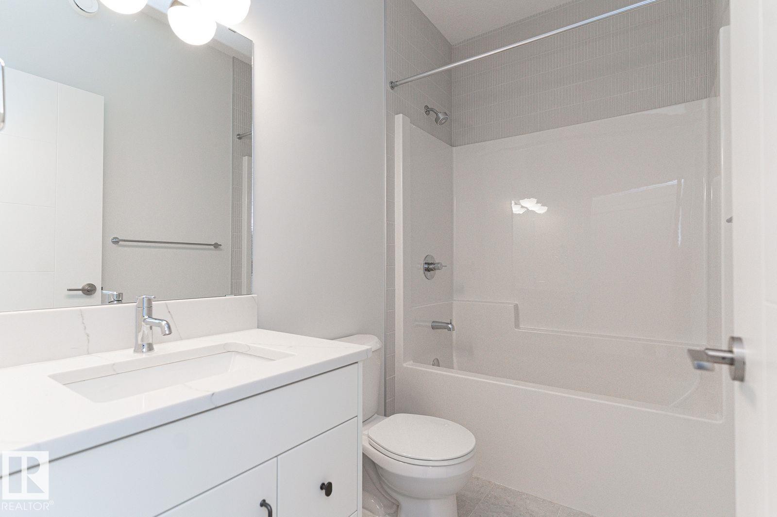 Bathroom vanity featuring a polished chrome faucet, integrated rectangular sink, and stone-finish countertop - 53 7121 May Crescent, Edmonton, AB - Indoor Photo Showing Bathroom
