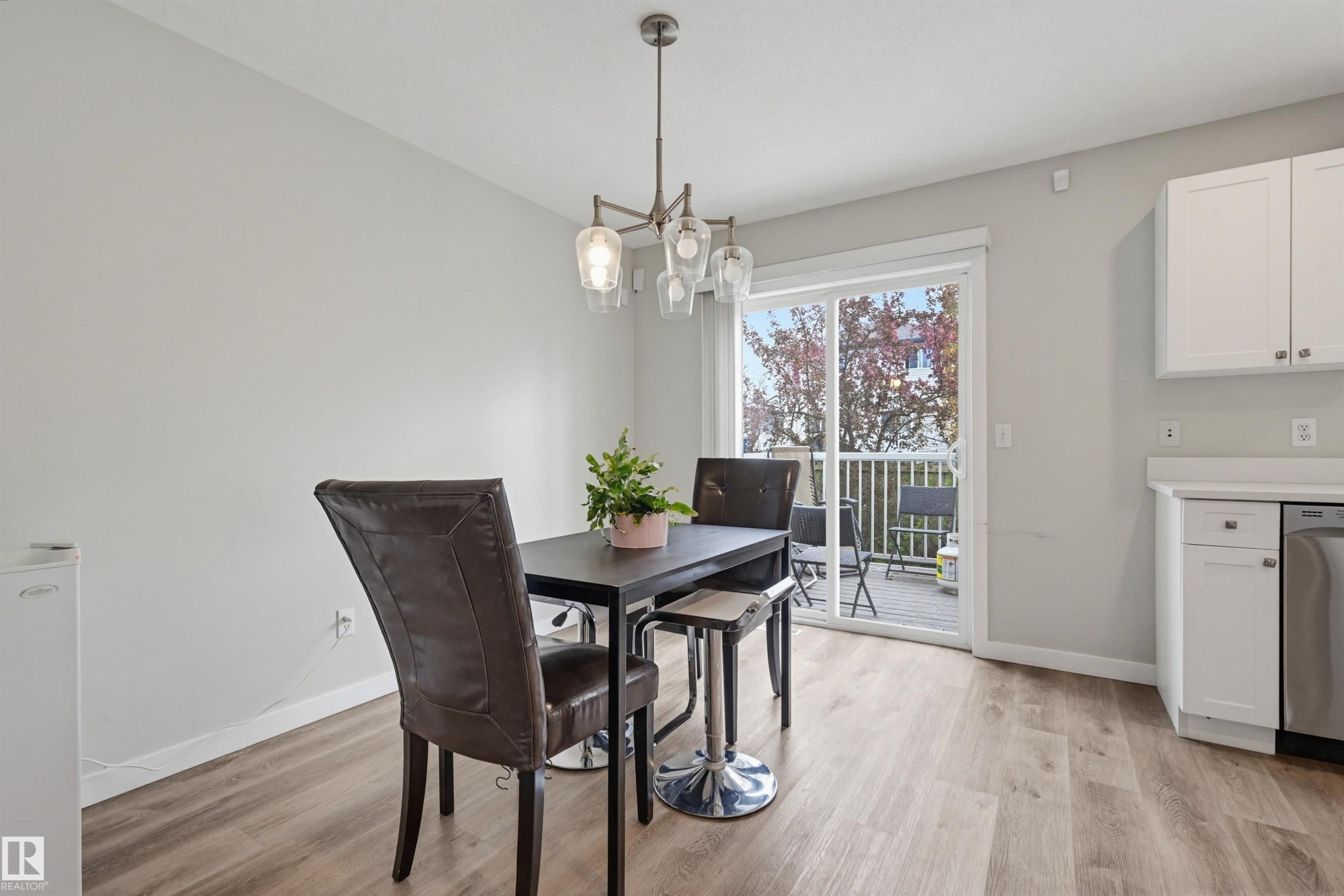 Dining area with wood-finish flooring and a contemporary chandelier - 11 3380 28A Avenue Nw, Edmonton, AB - Indoor Photo Showing Bathroom