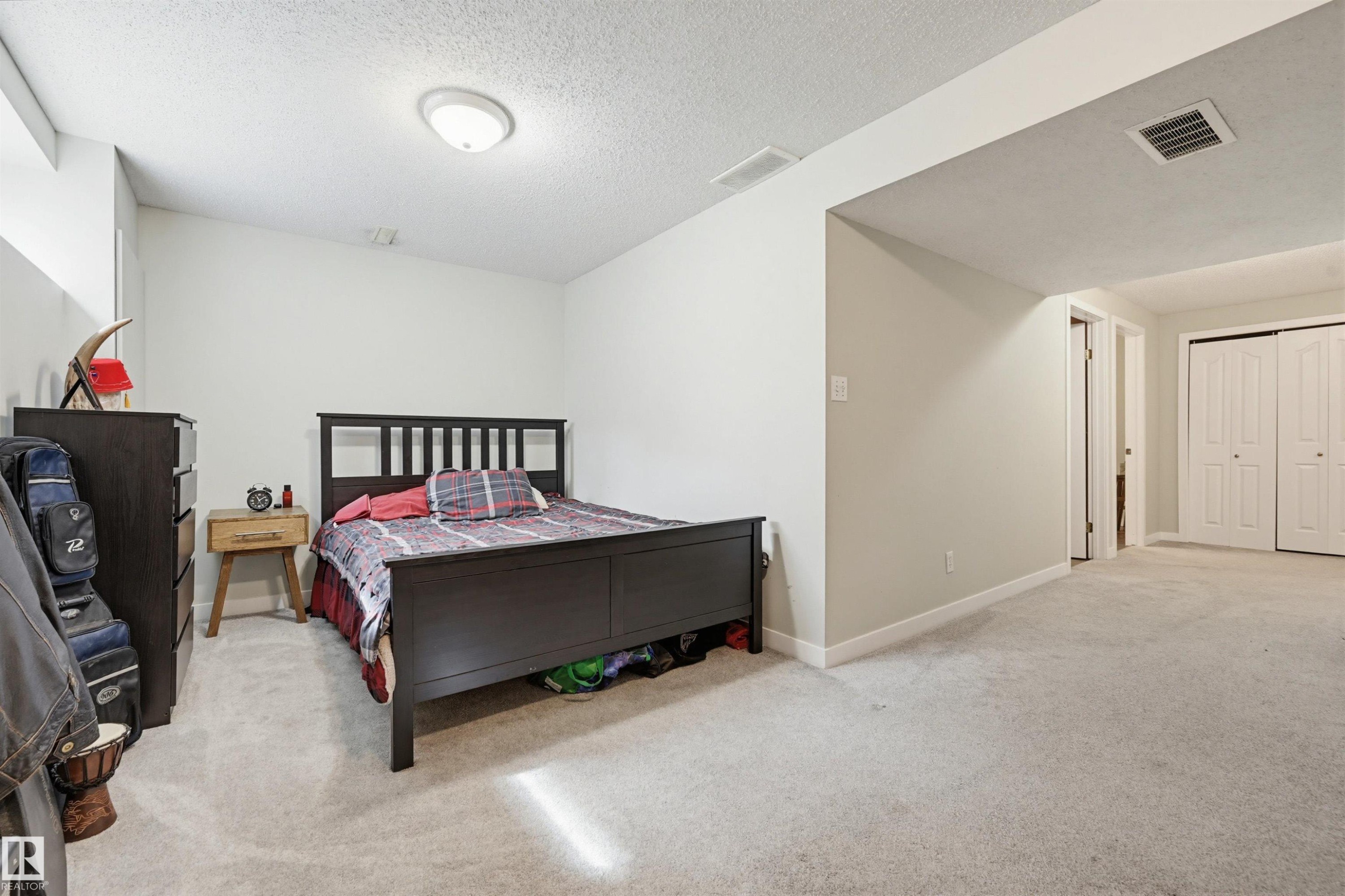 Spacious carpeted room featuring a neutral color palette, recessed lighting, and white trim - 11 3380 28A Avenue Nw, Edmonton, AB - Indoor