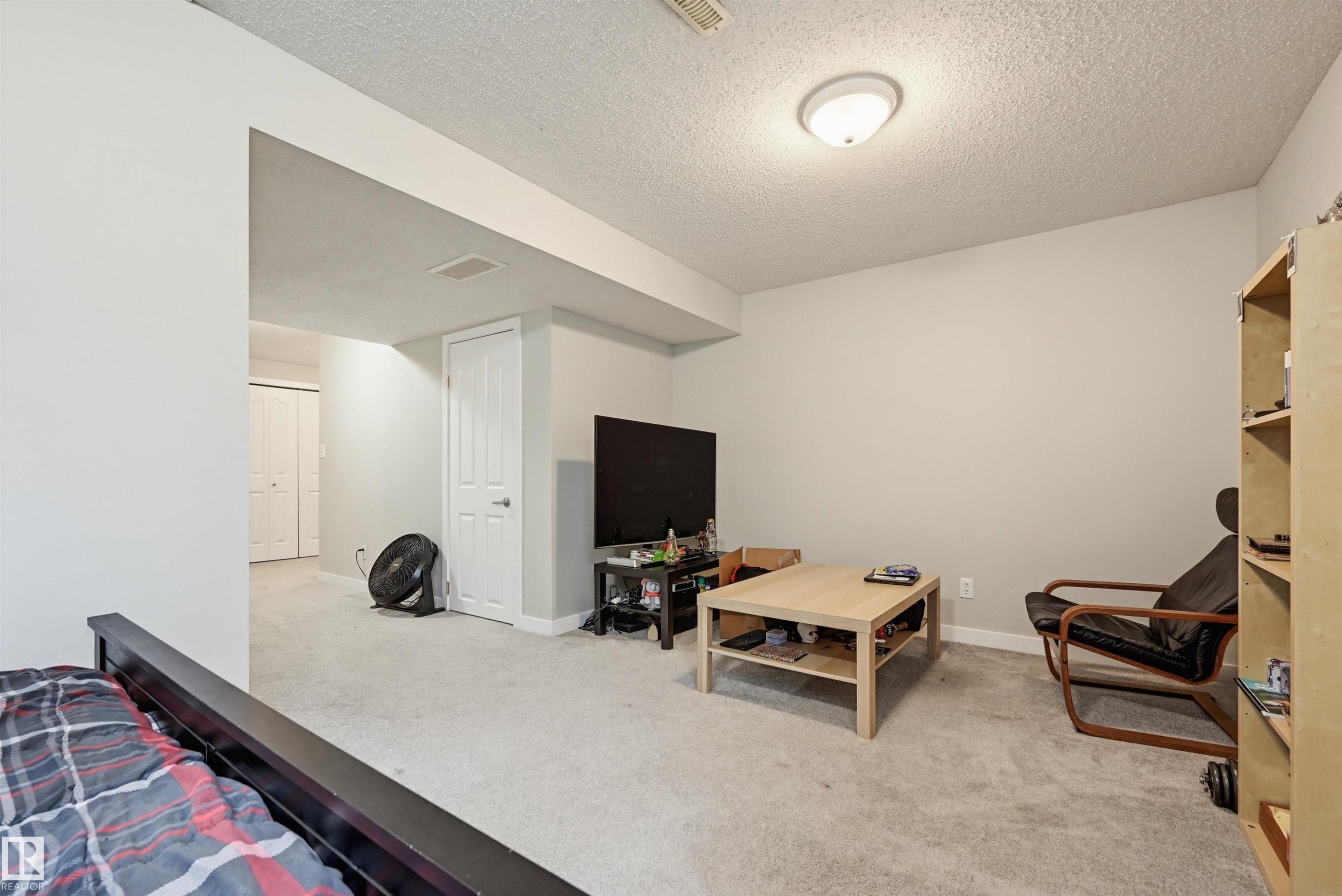 Carpeted room with neutral wall tones and a white ceiling - 11 3380 28A Avenue Nw, Edmonton, AB - Indoor Photo Showing Other Room
