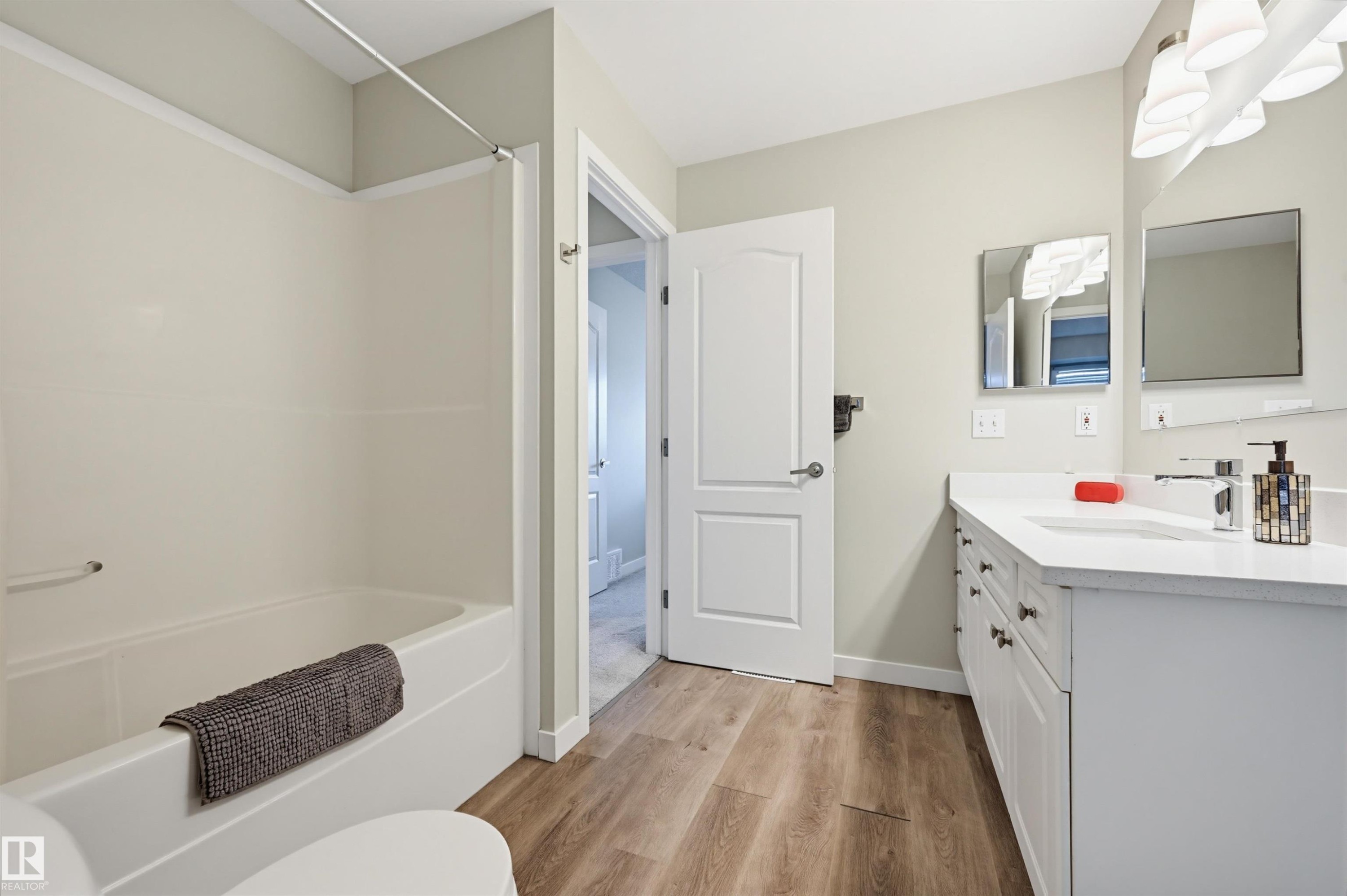 Full bathroom featuring a single white vanity with a white countertop, chrome faucet, and integrated sink - 11 3380 28A Avenue Nw, Edmonton, AB - Indoor Photo Showing Other Room
