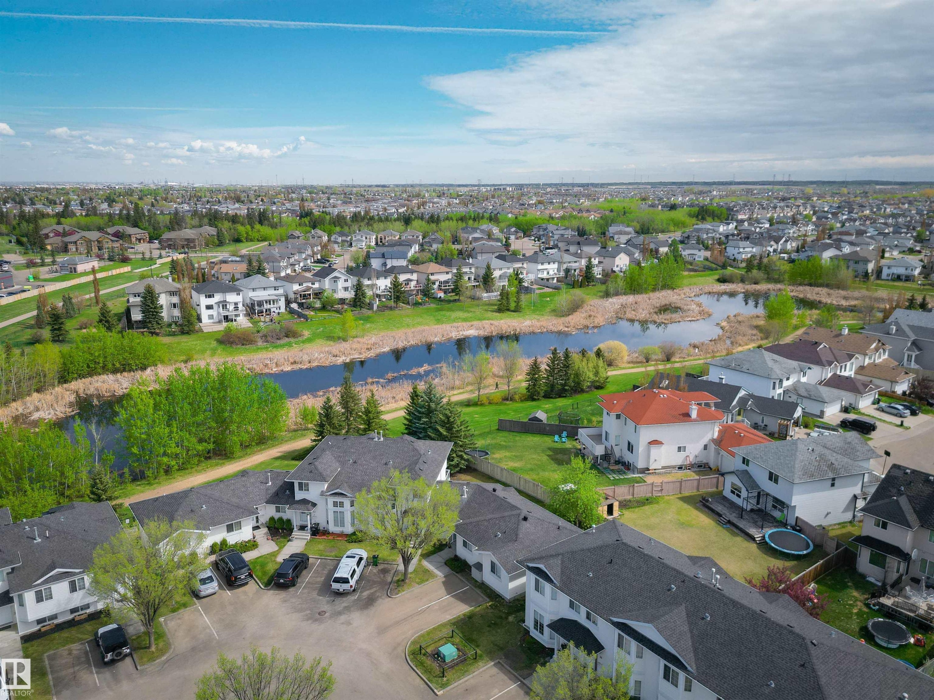 Residential community featuring a prominent pond with naturalized banks - 11 3380 28A Avenue Nw, Edmonton, AB - Outdoor With View