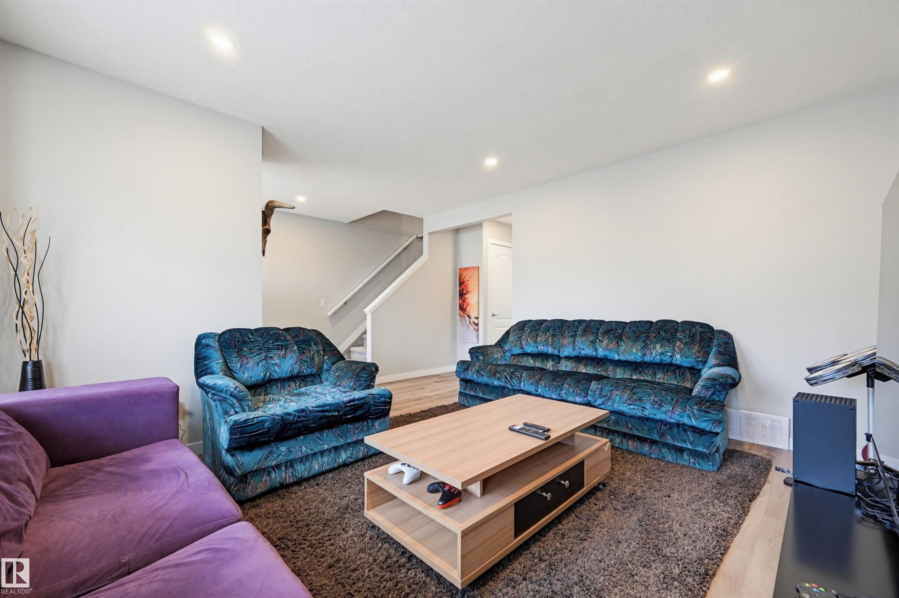 Spacious living area featuring light-toned walls and recessed lighting - 11 3380 28A Avenue Nw, Edmonton, AB - Indoor