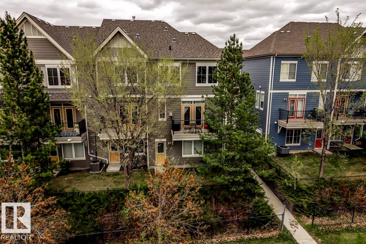Townhome exteriors featuring multiple levels, balconies with black railings, and a mix of siding materials - 67 603 Watt Boulevard, Edmonton, AB - Outdoor With Facade