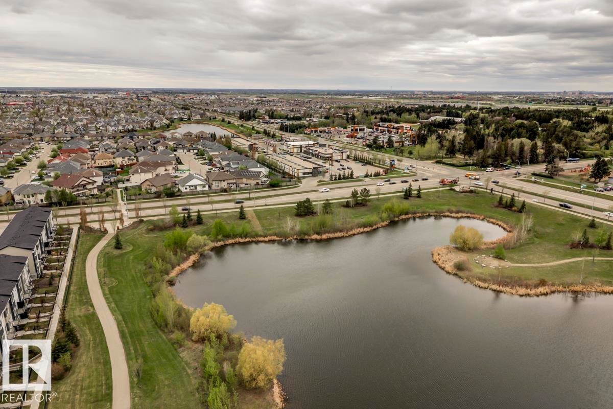 Expansive aerial capturing a neighborhood with varied residential structures and a large body of water - 67 603 Watt Boulevard, Edmonton, AB - Outdoor With Body Of Water With View
