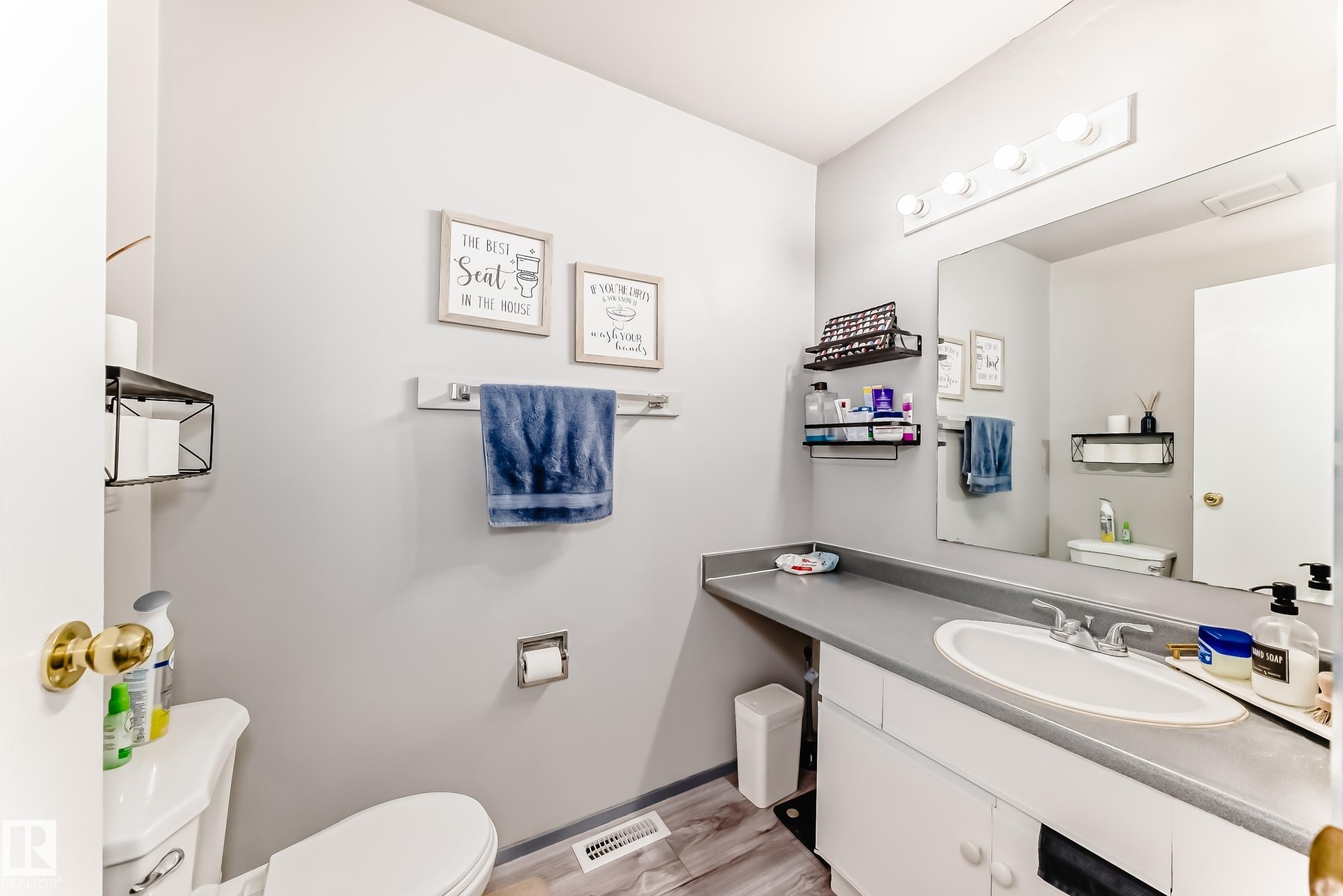 Bathroom featuring a single vanity with an integrated sink, a gray countertop, and white cabinetry - 214A Warwick Road, Edmonton, AB - Indoor Photo Showing Bathroom
