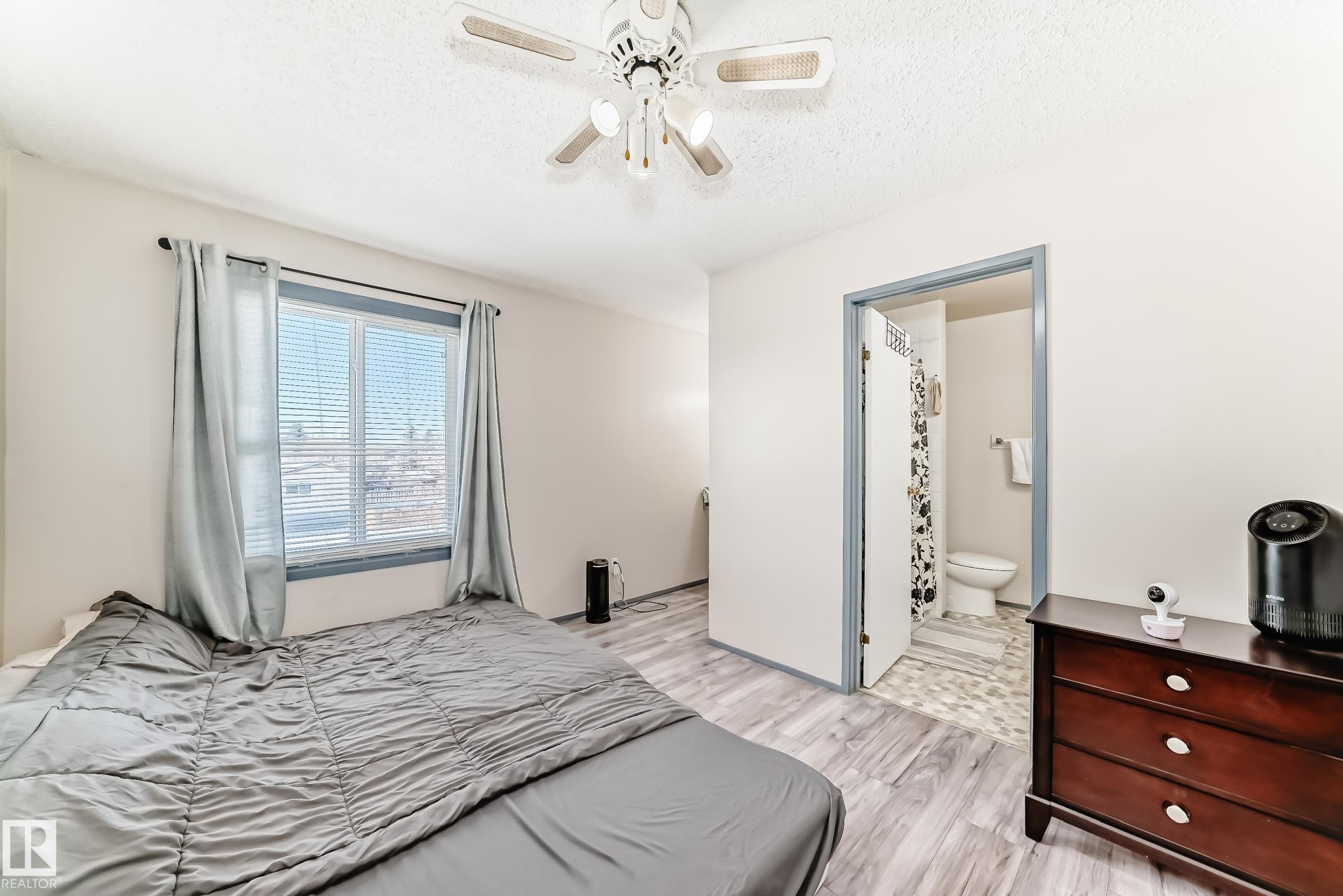Bedroom featuring wood-finish flooring, a ceiling fan with integrated lighting, and a window with blinds - 214A Warwick Road, Edmonton, AB - Indoor Photo Showing Bedroom